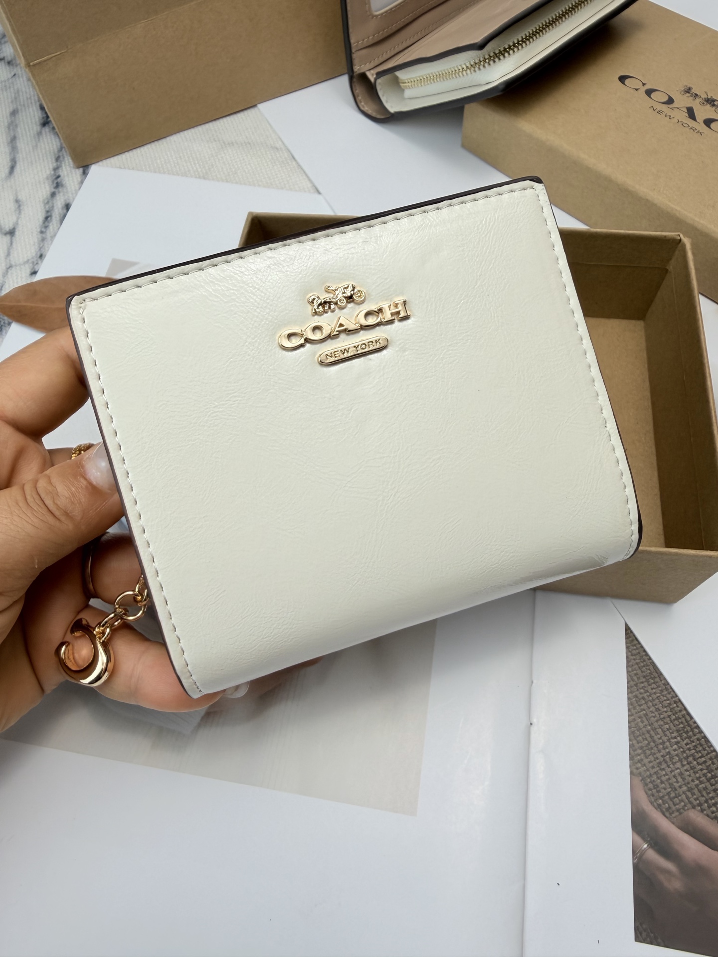 Coach COACH这款女士短款CCL79零钱卡包 采用优质白色漆皮配奶茶色平纹真皮设计 手感细腻耐用