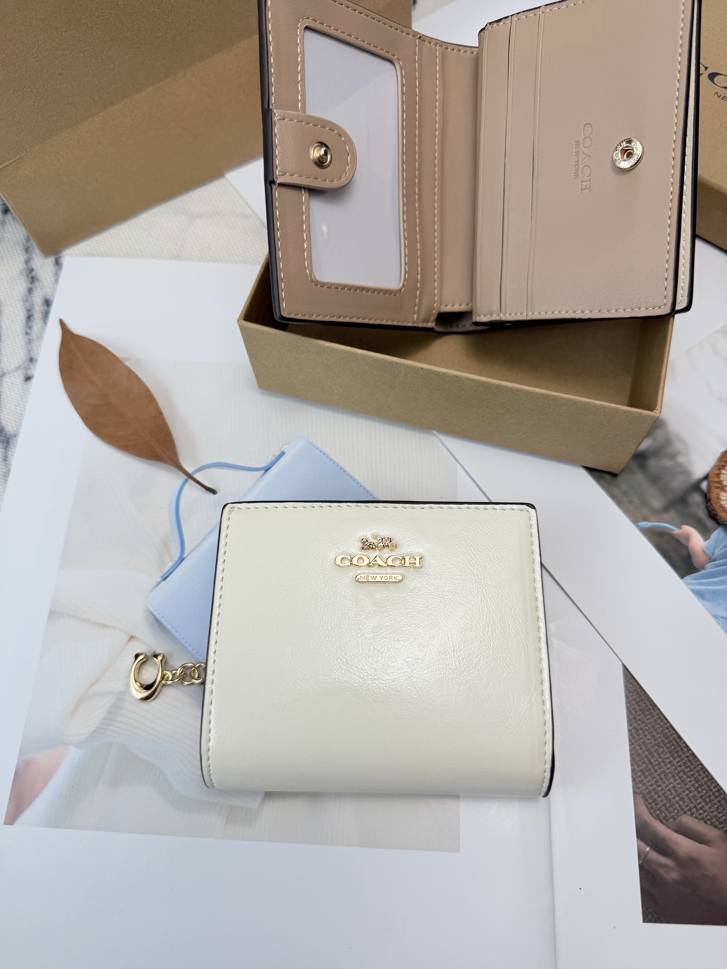 Coach COACH这款女士短款CCL79零钱卡包 采用优质白色漆皮配奶茶色平纹真皮设计 手感细腻耐用