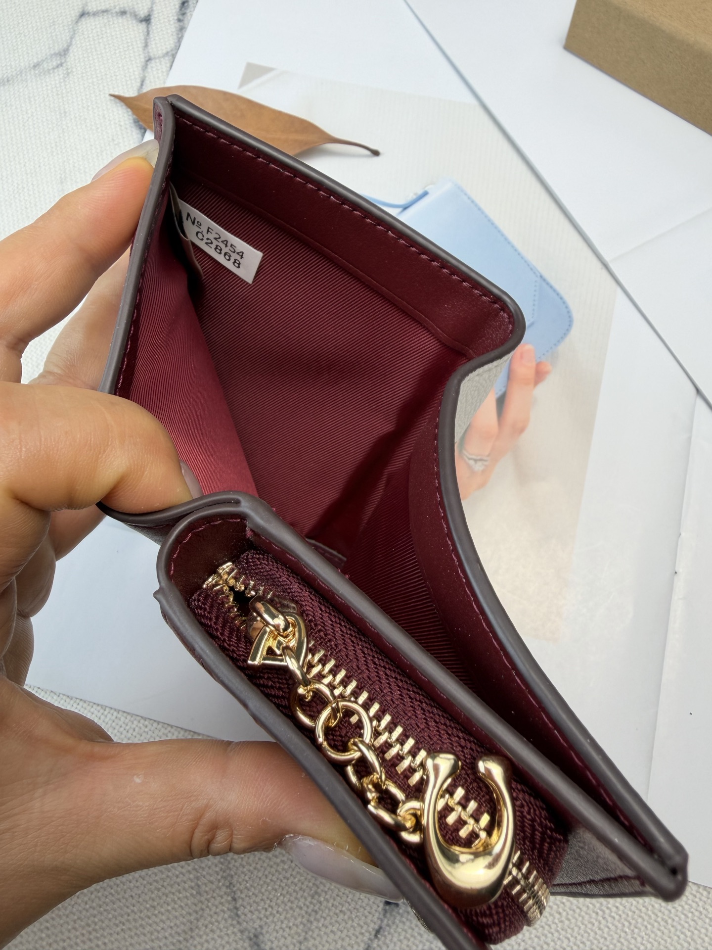 Coach Coach这款短款C2868零钱卡包 白色皮革搭配粉色爱心印花 酒红色内饰、俏皮又可爱