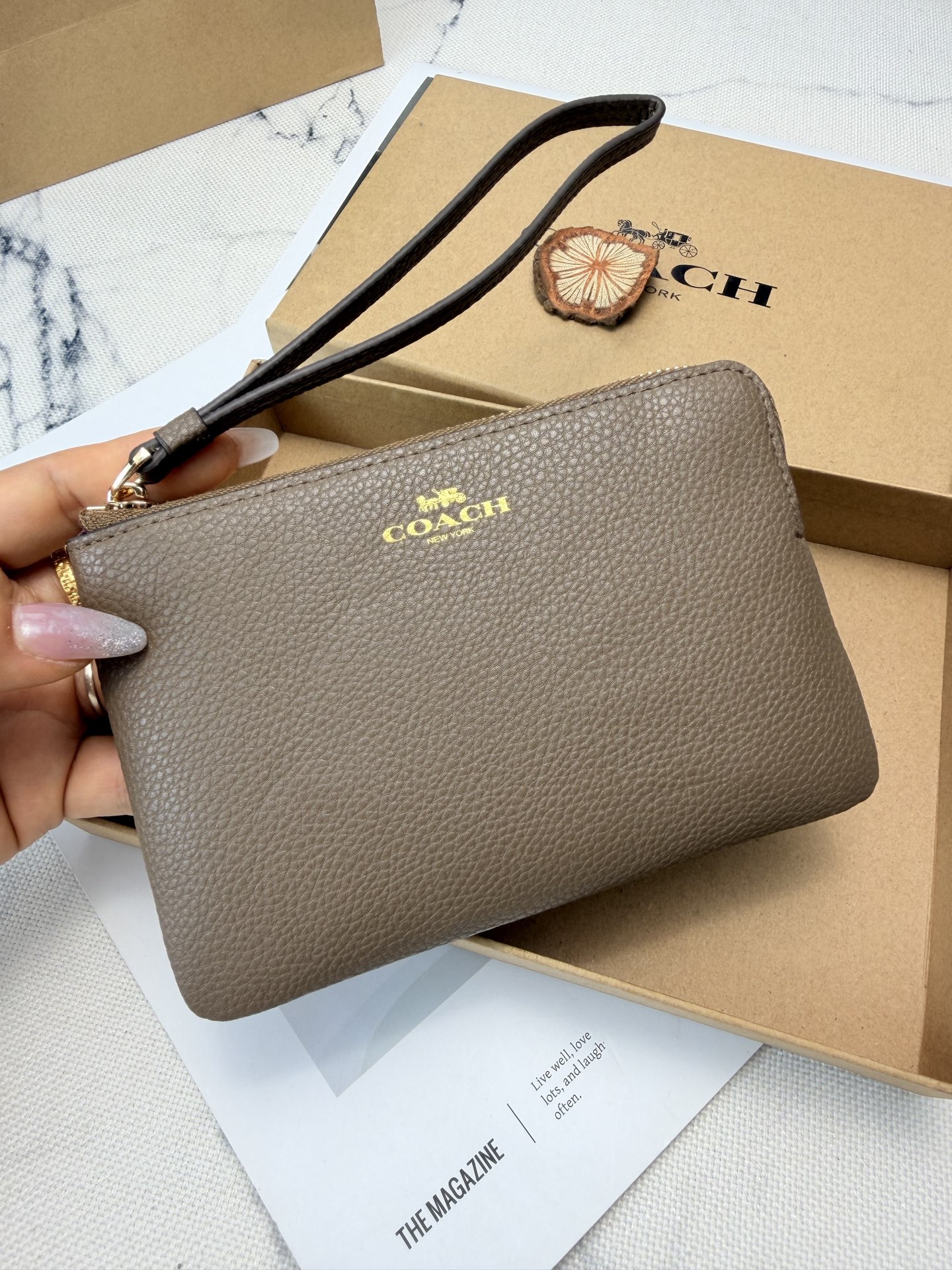 Coach COACH这款奶茶棕荔枝纹手拿包 款号CP483采用 C字Logo荔枝纹真皮革