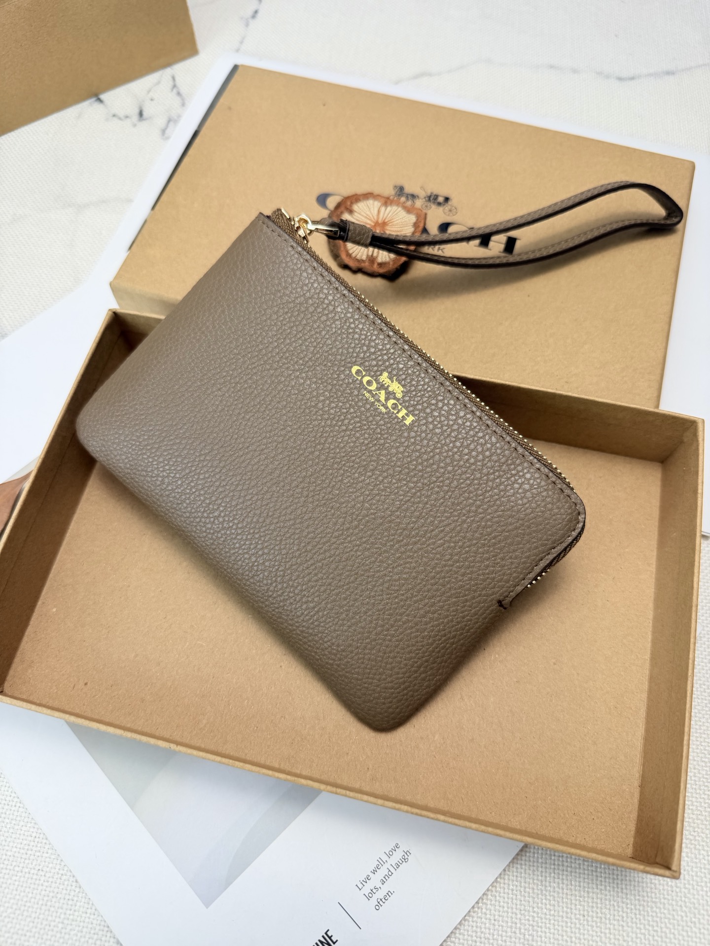 Coach COACH这款奶茶棕荔枝纹手拿包 款号CP483采用 C字Logo荔枝纹真皮革