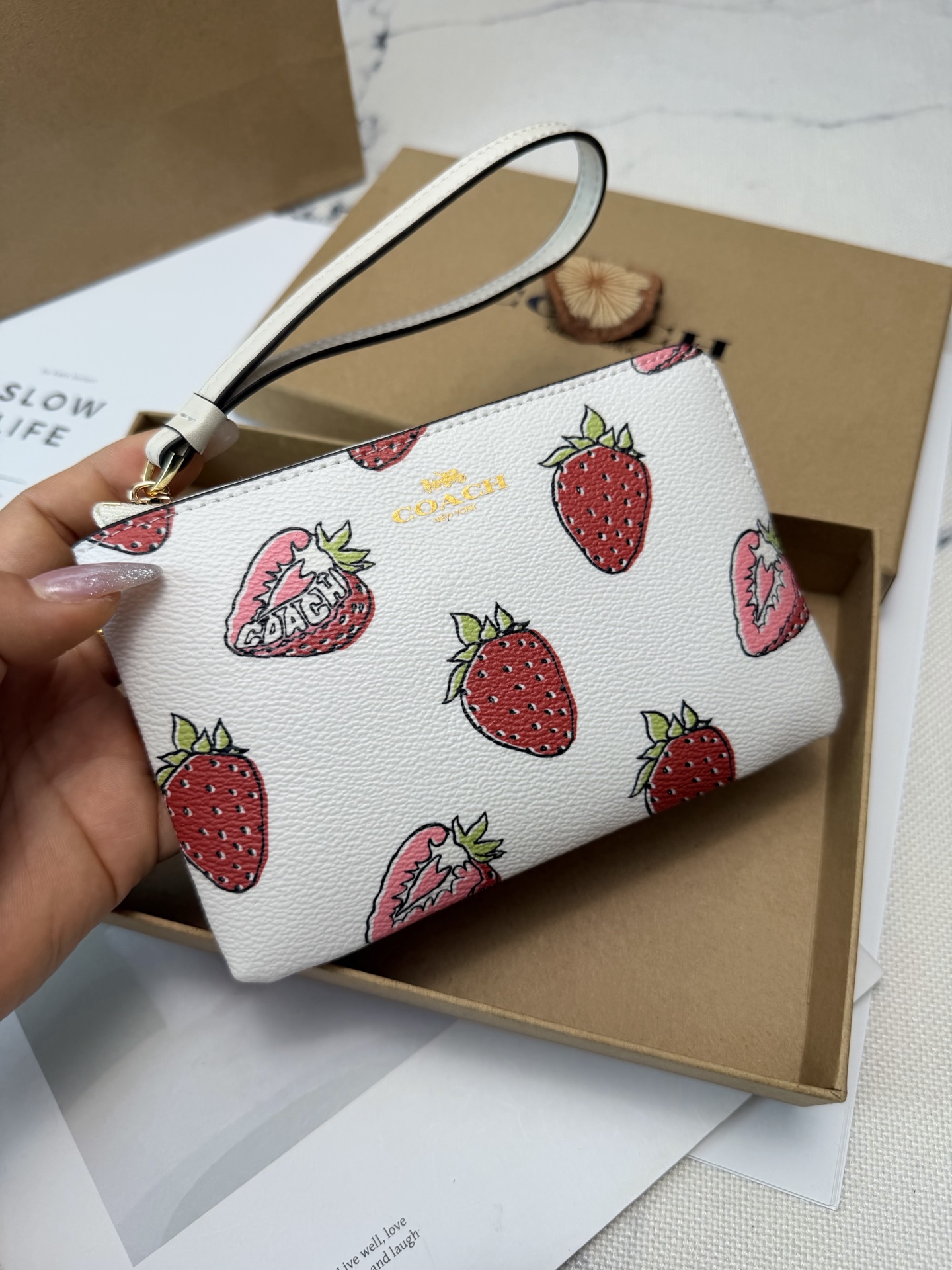 Coach 白色牛皮+红色草莓图案 夏日氛围感满满 金色丝印Logo点缀 品牌辨识度超高 使用了YKK拉链开合