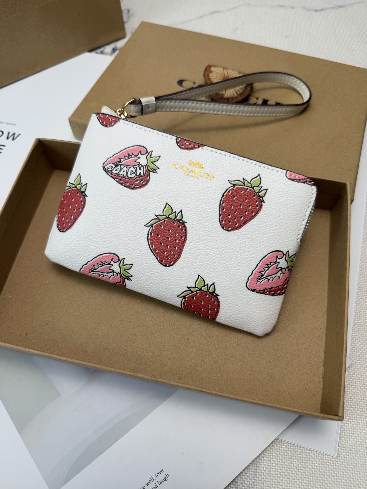 Coach 白色牛皮+红色草莓图案 夏日氛围感满满 金色丝印Logo点缀 品牌辨识度超高 使用了YKK拉链开合