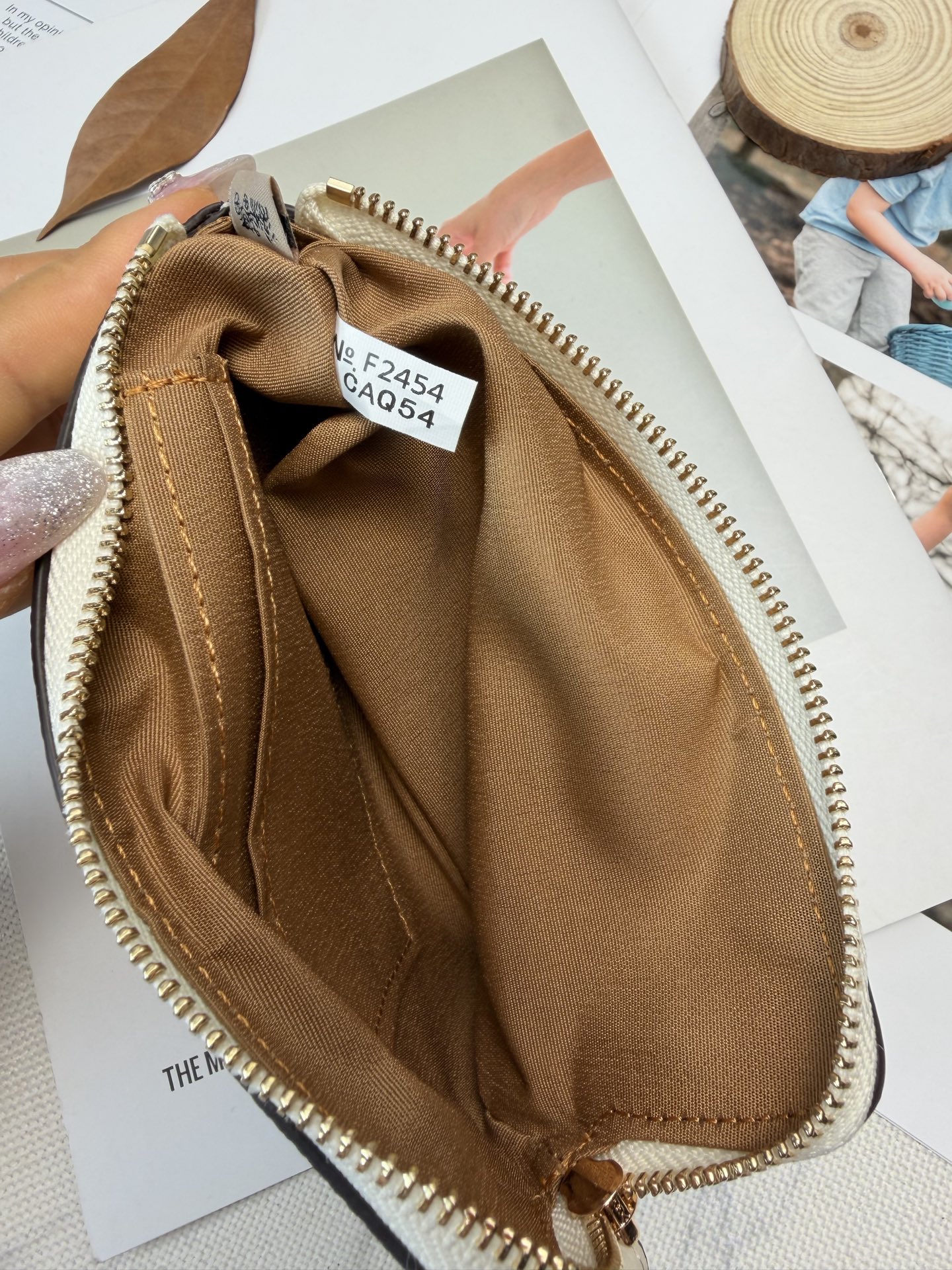 Coach Coach这款CAQ54涂鸦风零钱手拿包 采用白色荔枝纹皮革 手感细腻又耐用