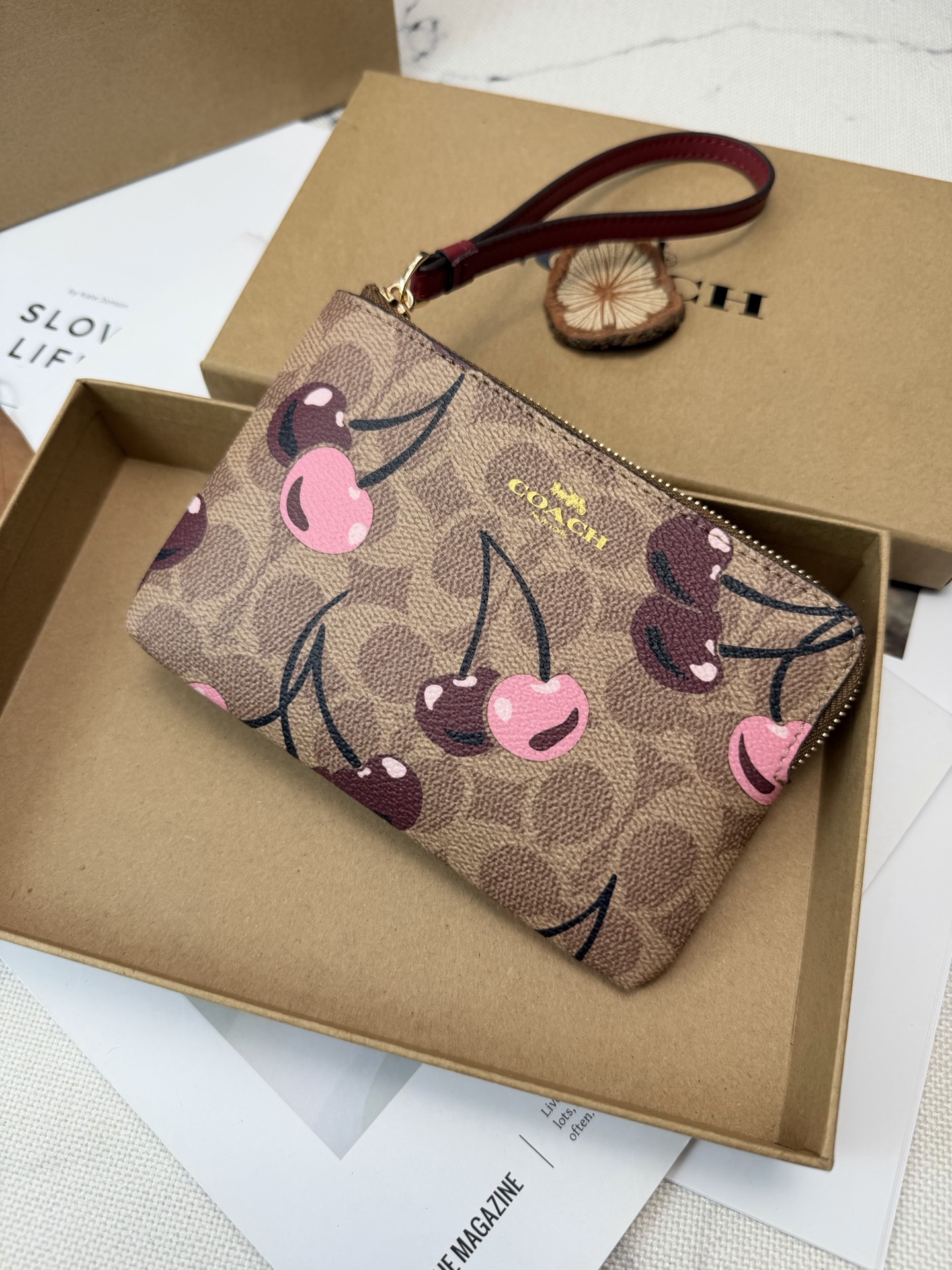 Coach 棕色老花帆布+樱桃图案 俏皮又 金色丝印Logo点缀 品牌辨识度超高 使用了YKK拉链开合