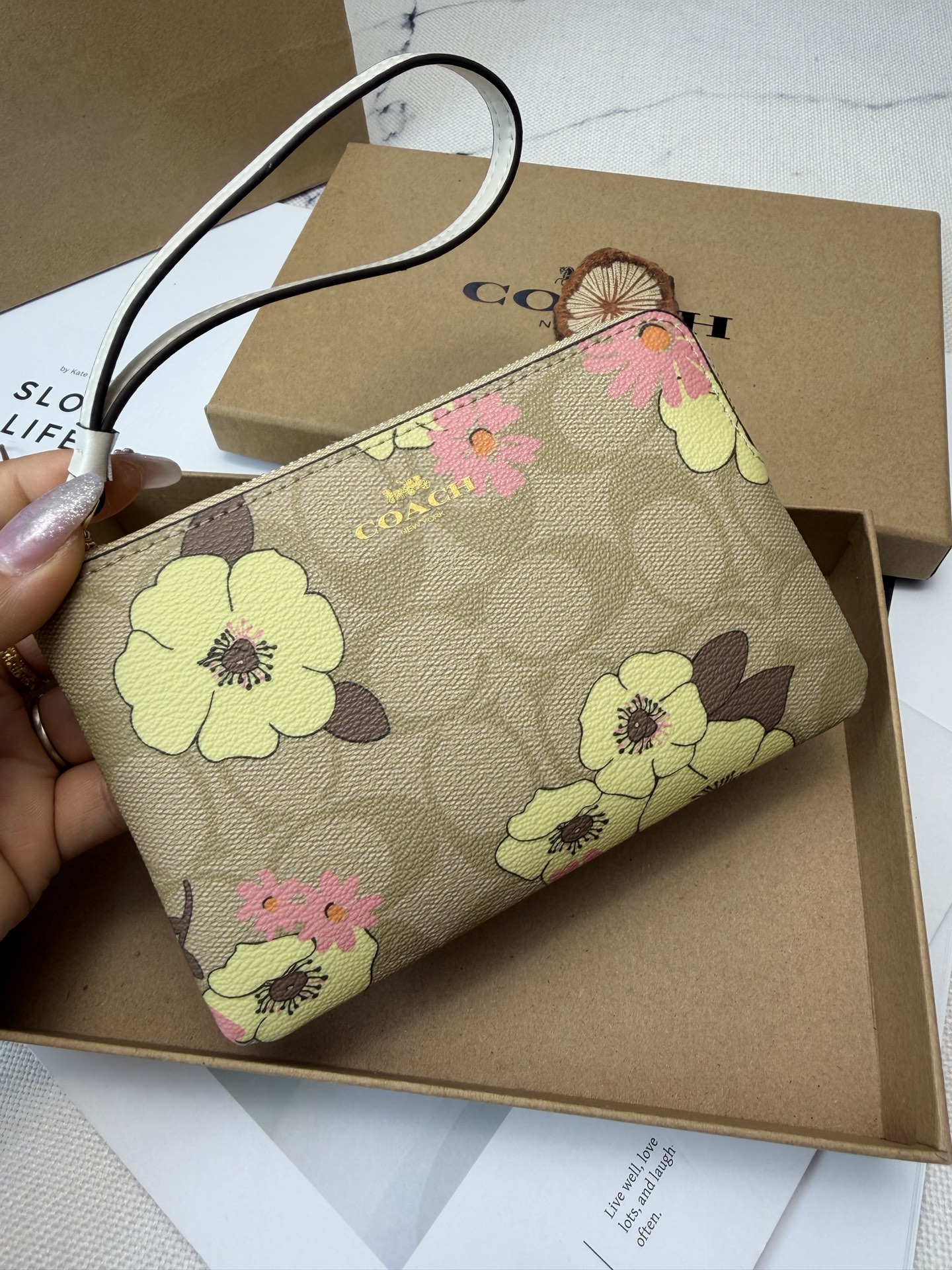 Coach COACH这款Cl856零钱手拿包采用 老花帆布 搭配黄粉花卉印花 优雅又 金色丝印Logo点缀
