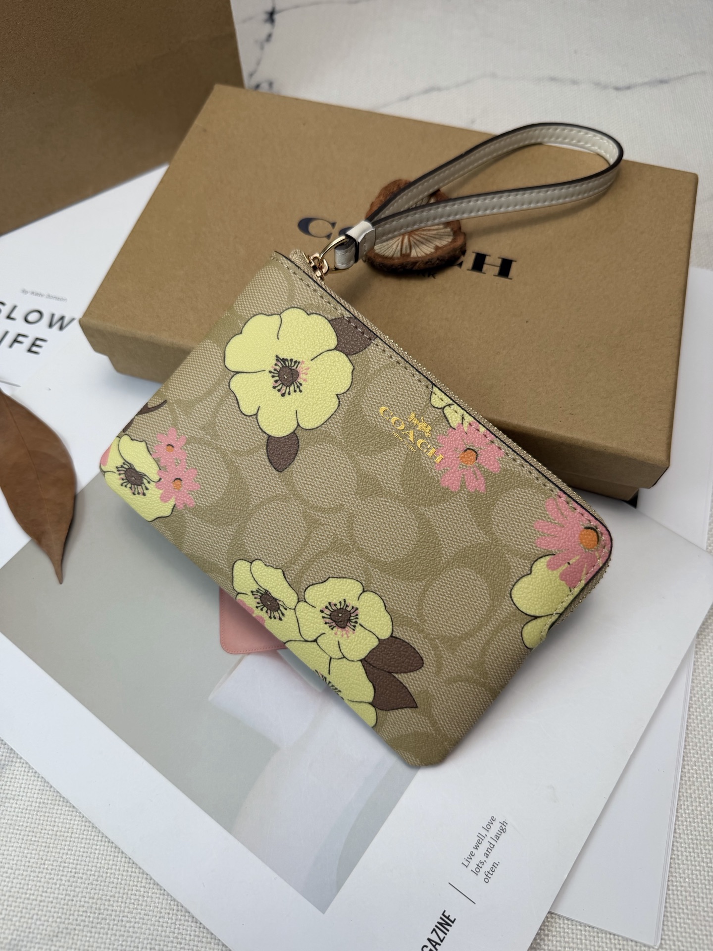 Coach COACH这款Cl856零钱手拿包采用 老花帆布 搭配黄粉花卉印花 优雅又 金色丝印Logo点缀