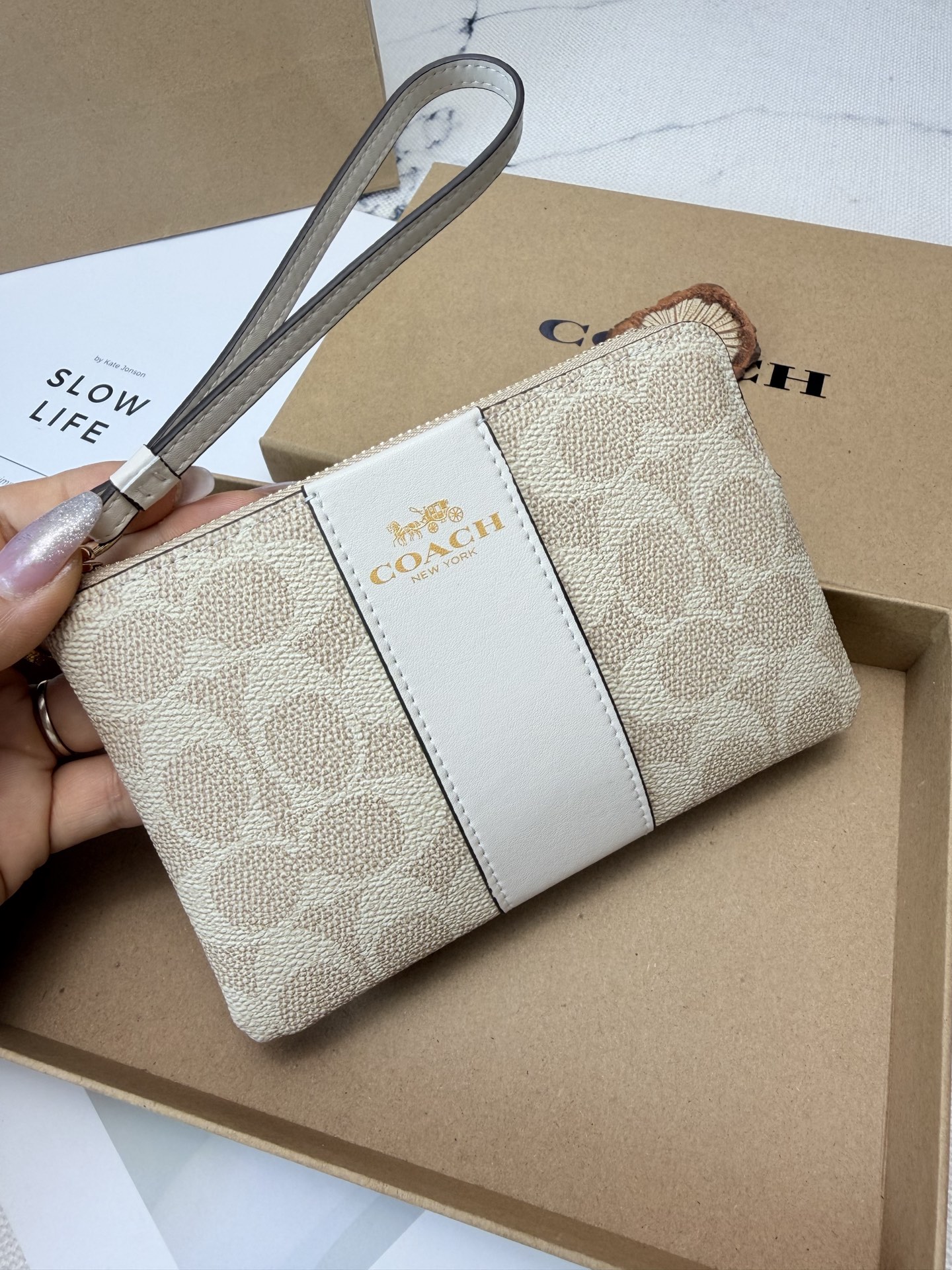 Coach Coach这款CW854奶茶色零钱手腕包 老花帆布+白色皮革饰边 优质皮革+按扣开合