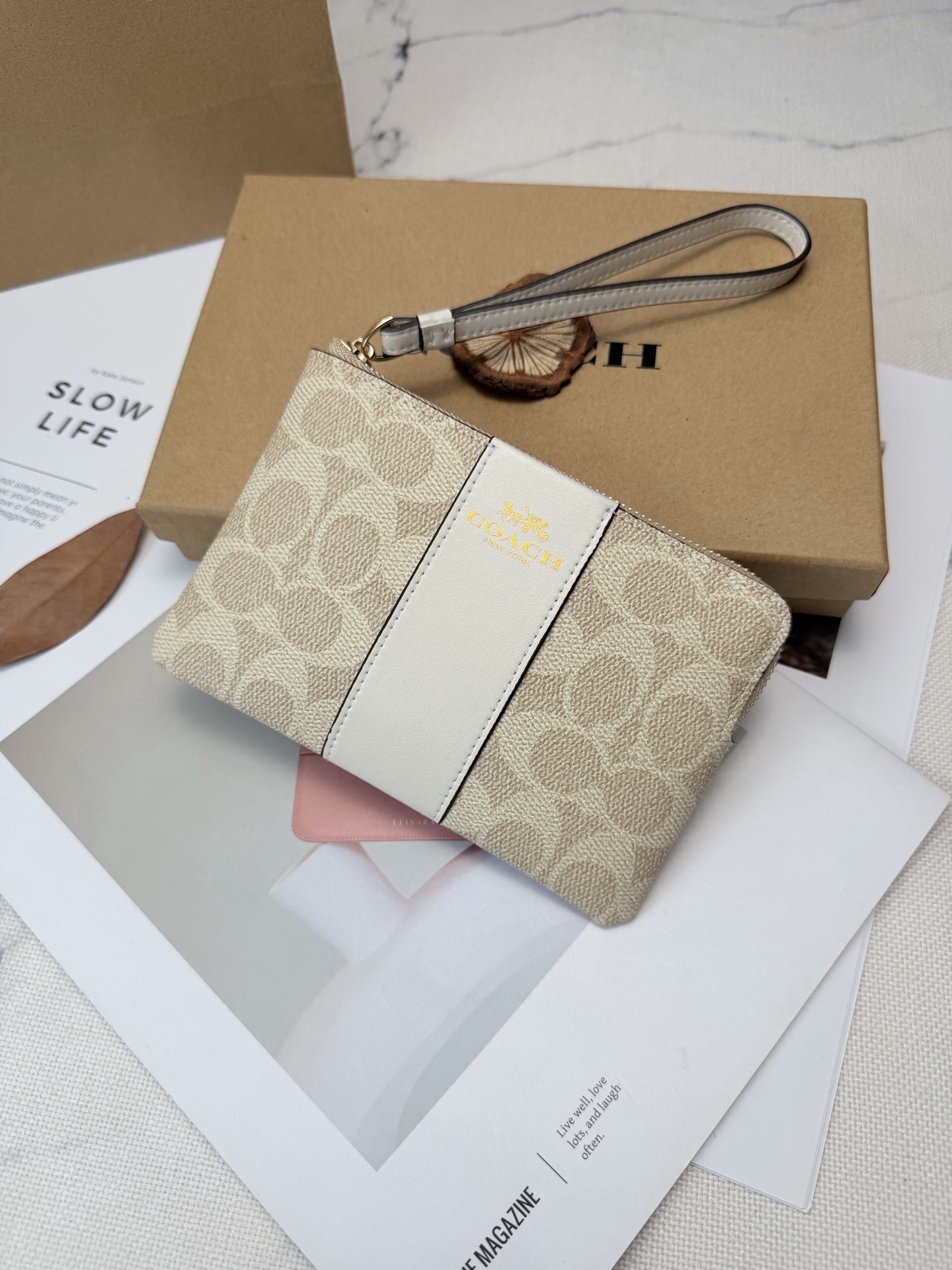 Coach Coach这款CW854奶茶色零钱手腕包 老花帆布+白色皮革饰边 优质皮革+按扣开合