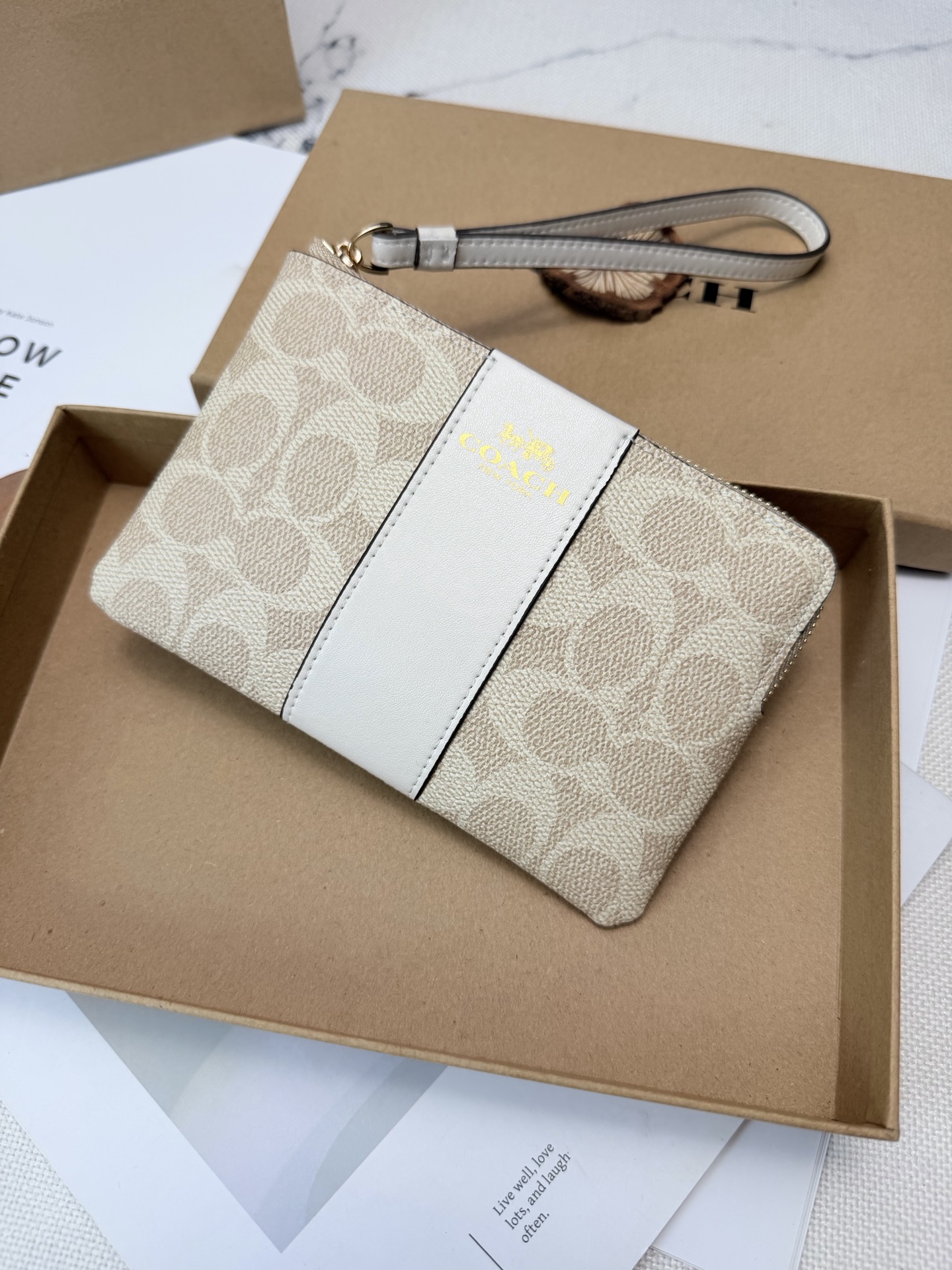 Coach Coach这款CW854奶茶色零钱手腕包 老花帆布+白色皮革饰边 优质皮革+按扣开合