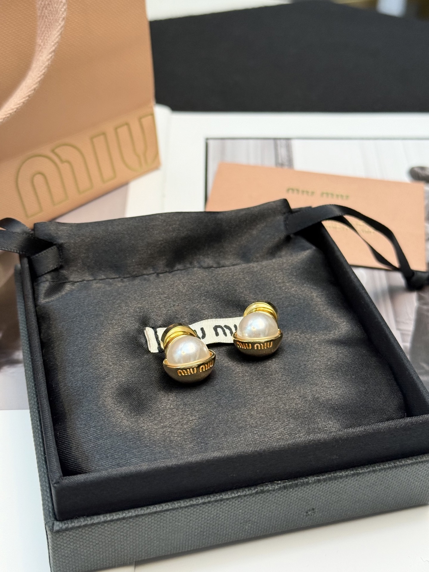 p90 Miu Miu珍珠耳钉
Miu Miu这款珍珠耳钉，金属镀金底座+圆形仿珍珠，优雅复古风满满!底座刻有品牌Logo，细节超精致💎仿珍珠光泽柔和，日常或正式场合都能轻松驾驭~耳堵设计佩戴稳固不易掉，舒适又时髦，适合喜欢精致配饰的姐妹们💕
