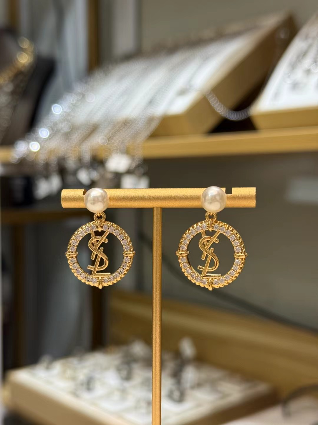 p95
 YSL圣罗兰珍珠耳环
✨YSL圣罗兰珍珠耳环，经典Logo设计，金色金属搭配米白色珍珠和镶钻圆环，优雅又奢华。珍珠圆润光泽，修饰脸型，提升气质💎 .Logo细节精致，彰显品牌辨识度，日常或正式场合都能轻松驾驭，时尚感满分!