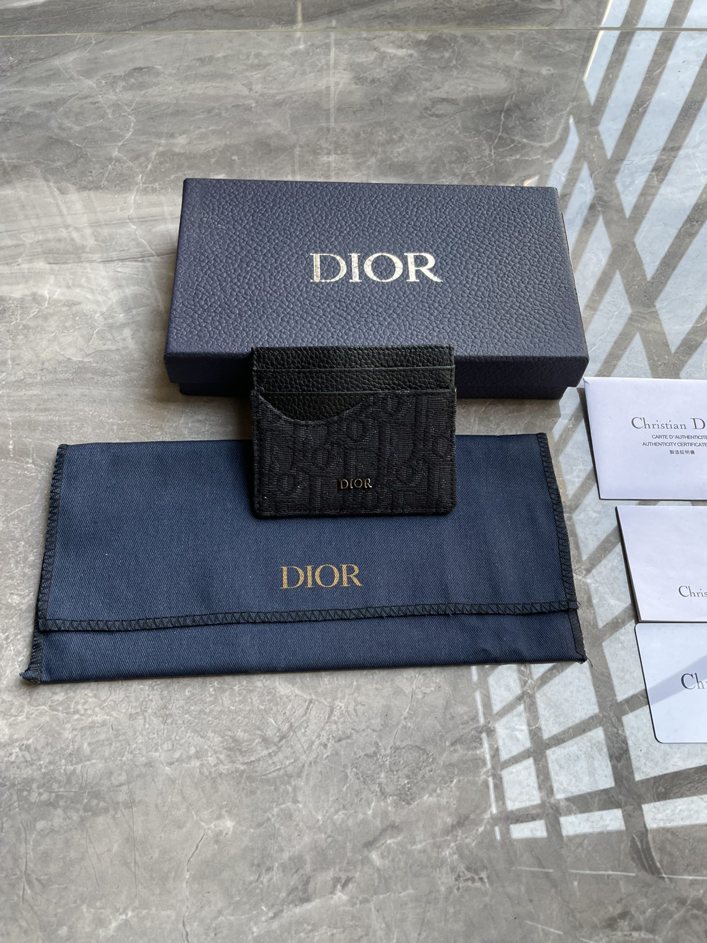 NO:204710,Saddle clip Black finely inlaid grained cowhide with black Oblique print No.: 2ADCH164YKS_H03E Size 10×8 (length x height) This saddle clip is an elegant accessory that highlights Dior's exquisite leather inlay. It is carefully crafted with black grained cowhide with Oblique prints to highlight the classic silhouette of the saddle series. There are three card slots on both sides and a card slot in the center of the top to store various personal items. The style is elegant, the front is decorated with Dior logo, which can be easily placed in various pockets. 6 card slots center card slot ticket insert bag. Metal cladding on the front is decorated with a Dior embossed logo. The inside of the logo is decorated with a Dior embossed logo. It contains dust bags, Prada, dior, prada, cowhide19860909马鞍卡夹 黑色细工镶嵌粒面牛皮革搭配黑色Oblique 印花 编号:2ADCH164YKS_H03E 尺寸10×8（长x高）这款马鞍卡夹是一款高雅的配饰,彰显Dior精湛的皮革细工镶嵌工艺.采用黑色粒面牛皮革搭配Oblique 印花精心制作,突显马鞍系列的经典廓形,两侧各设有三个卡槽,顶部中央设有一个卡槽,可收纳各种个人物品.款式优雅,正面饰以Dior标志,可轻松放入各式口袋中.6个卡槽中央卡槽票据插袋 正面金属覆层黄铜Dior 标志内侧饰有Dior压花标志内含防尘袋,普拉达,dior,prada,cowhide,Bag