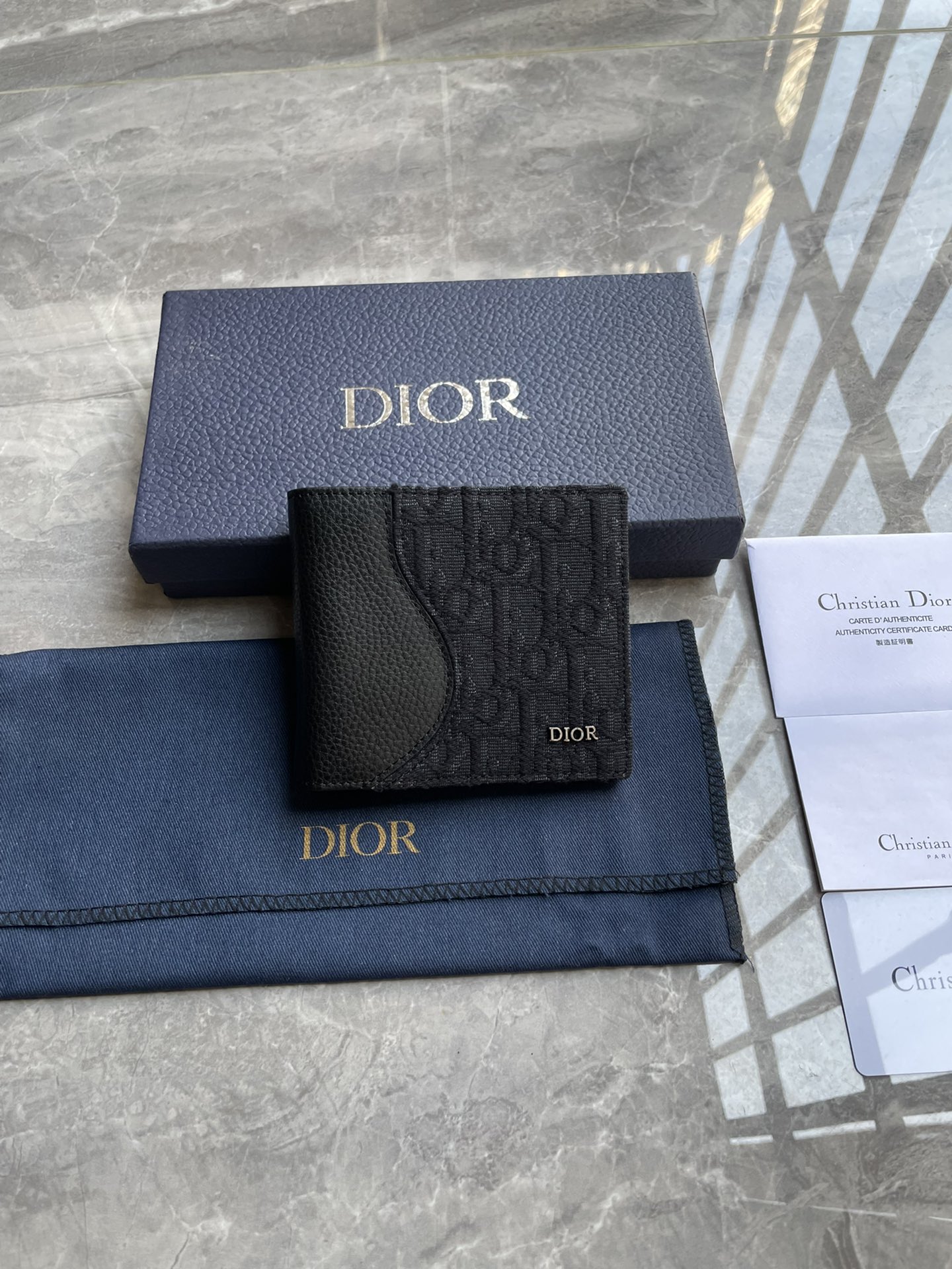 NO:204700,Saddle double-fold card clip Black finely inlaid grained cowhide with black Oblique print Number: 2ADBH076YKS_H03E Size 11.5×9.5×3cm (Length x Height x Width) This saddle double-fold card clip is an elegant accessory that highlights the exquisite craftsmanship of Dior. It is carefully crafted with black finely inlaid grained cowhide with Oblique prints to highlight the classic saddle profile. It has a double-layer cash compartment, two bill insert bags and eight card slots inside. The bifold design is decorated with metal-clad brass Dior logo on the front, which can be easily placed in various pockets or handbags. The interior is made of 8 card slots with smooth cowhide with 2 bill insert bags double-layer cash compartment  The front metal cladding brass Dior logo is decorated with Dior embossed logo. It contains dust bags, prada, dior, prada, cowhide19860909马鞍双折卡夹 黑色细工镶嵌粒面牛皮革搭配黑色Oblique 印花 编号:2ADBH076YKS_H03E 尺寸11.5×9.5×3厘米（长x高×宽） 这款马鞍双折卡夹是一款高雅的配饰,彰显Dior的精湛工艺.采用黑色细工镶嵌粒面牛皮革搭配Oblique 印花精心制作,突显经典的马鞍廓形,内部设有一个双层现金隔层、两个票据插袋和八个卡槽.双折设计,正面饰以金属覆层黄铜Dior标志,可轻松放入各式口袋或手袋中.内部采用光滑牛皮革8个卡槽 2个票据插袋双层现金隔层 正面金属覆层黄铜Dior标志内侧饰有Dior压花标志内含防尘袋,普拉达,dior,prada,cowhide,Bag