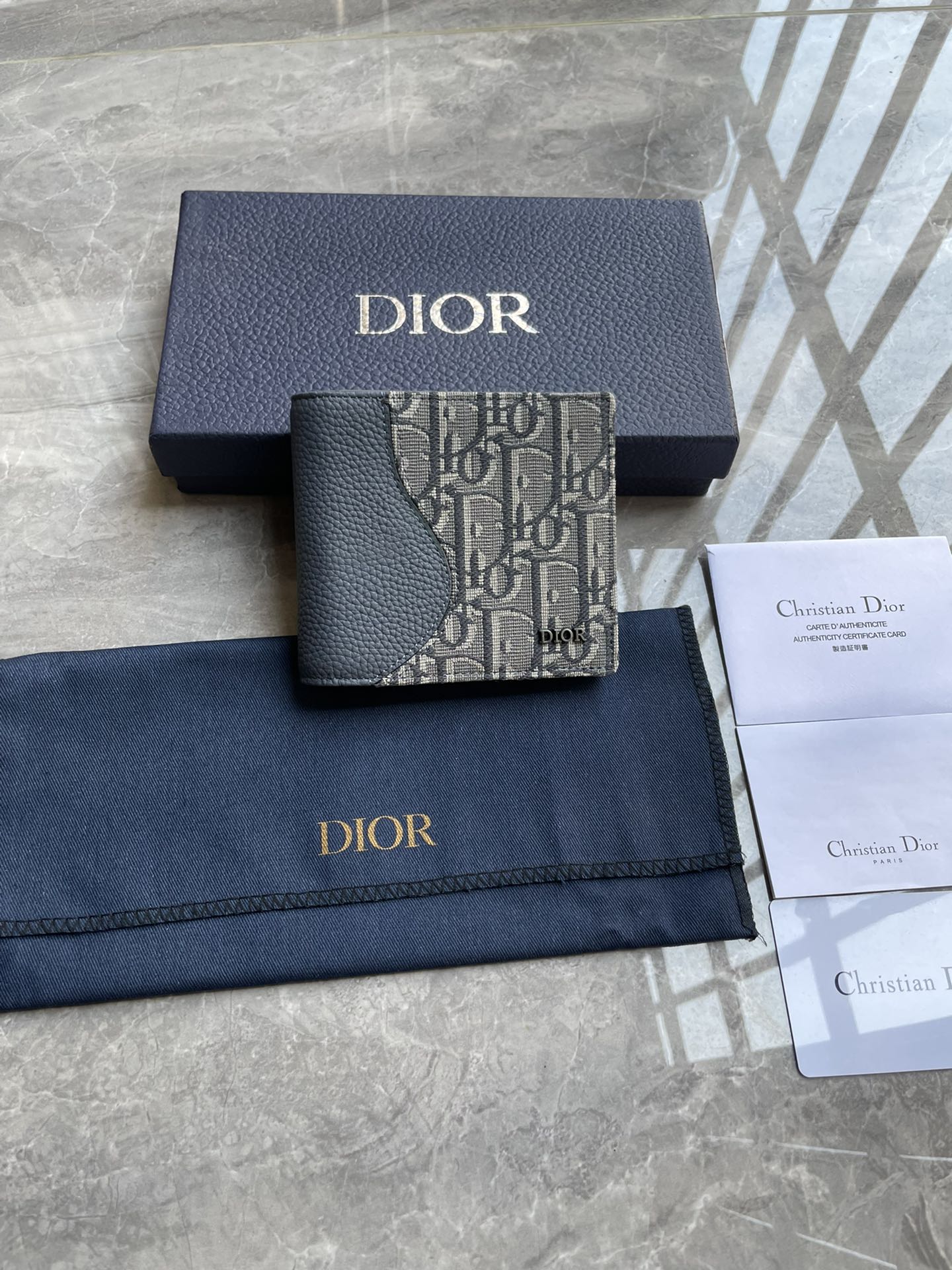 NO:204706,Saddle double-fold card clip Dark gray finely inlaid grained cowhide leather and dark gray Oblique printed fabric 4, number: 2ADBH076YKS_H12E Size 11.5×9.5×3 (L x H x W) This saddle double-fold card clip is an elegant accessory that highlights the exquisite craftsmanship of Dior. It is carefully crafted in dark gray finely inlaid grained cowhide leather with Oblique prints to highlight the classic saddle profile, with a double-layer cash compartment, two bill insert bags and eight card slots inside. The bifold style is decorated with metal-clad brass Dior logo on the front, which can be easily placed in various pockets or handbags. The interior is made of smooth cowhide leather 8 card clip 2 bill insert bags Double-layer cash compartment The front is decorated with metal-clad brass Dior logo on the inside.  Embossed logo contains dust bag, prada, dior, prada, cowhide19860909马鞍双折卡夹 深灰色细工镶嵌粒面牛皮革和深灰色Oblique 印花面料4, 编号:2ADBH076YKS_H12E 尺寸11.5×9.5×3（长x高x宽）这款马鞍双折卡夹是一款高雅的配饰,彰显Dior的精湛工艺.采用深灰色细工镶嵌粒面牛皮革搭配Oblique 印花精心制作,突显经典的马鞍廓形,内部设有一个双层现金隔层、两个票据插袋和八个卡槽.双折款式,正面饰以金属覆层黄铜Dior标志,可轻松放入各式口袋或手袋中. 内部采用光滑牛皮革8 个卡槽 2个票据插袋双层现金隔层 正面饰以金属覆层黄铜Dior 标志内侧饰有 Dior 压花标志内含防尘袋,普拉达,dior,prada,cowhide,Bag