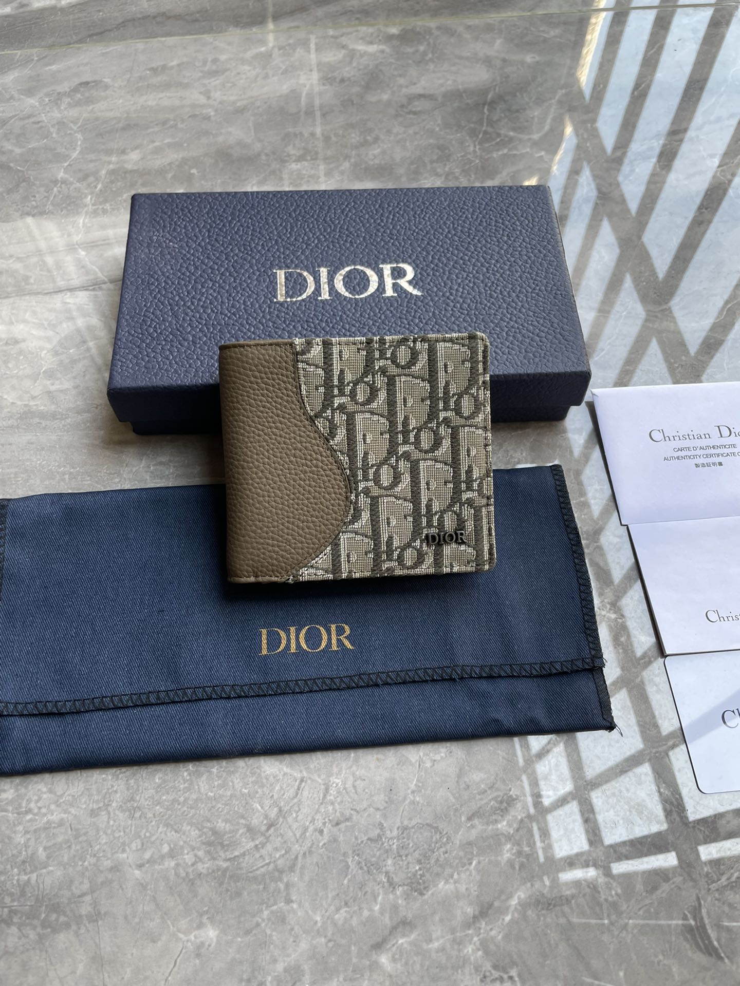 NO:204712,Saddle double-fold card clip Khaki fine-crafted grained cowhide leather with khaki Oblique print 4, number: 2ADBH076YKS_H57E Size 11.5×9.5×3 (Length x Height x Width) This saddle double-fold card clip is an elegant accessory that highlights the exquisite craftsmanship of Dior. It is carefully crafted with khaki fine-crafted grained cowhide leather with Oblique prints to highlight the classic saddle profile. It has a double-layer cash compartment, two bill insert bags and eight card slots inside. The bifold style is decorated with Dior logo on the front, which can be easily placed in various pockets and handbags. The interior is made of smooth cowhide leather 8 card slots 2 bill insert bags Double-layer cash compartment The front is decorated with metal cladding brass Dior logo on the inside.  Embossed logo contains dust bag, prada, dior, prada, cowhide19860909马鞍双折卡夹 卡其色细工镶嵌粒面牛皮革搭配卡其色Oblique 印花4, 编号:2ADBH076YKS_H57E 尺寸11.5×9.5×3（长x高x宽）这款马鞍双折卡夹是一款高雅的配饰,彰显Dior的精湛工艺.采用卡其色细工镶嵌粒面牛皮革搭配Oblique印花精心制作,突显经典的马鞍廓形,内部设有一个双层现金隔层、两个票据插袋和八个卡槽.双折款式,正面饰以Dior标志,可轻松放入各式口袋和手袋中. 内部采用光滑牛皮革8个卡槽 2个票据插袋双层现金隔层 正面饰以金属覆层黄铜Dior 标志内侧饰有Dior 压花标志内含防尘袋,普拉达,dior,prada,cowhide,Bag