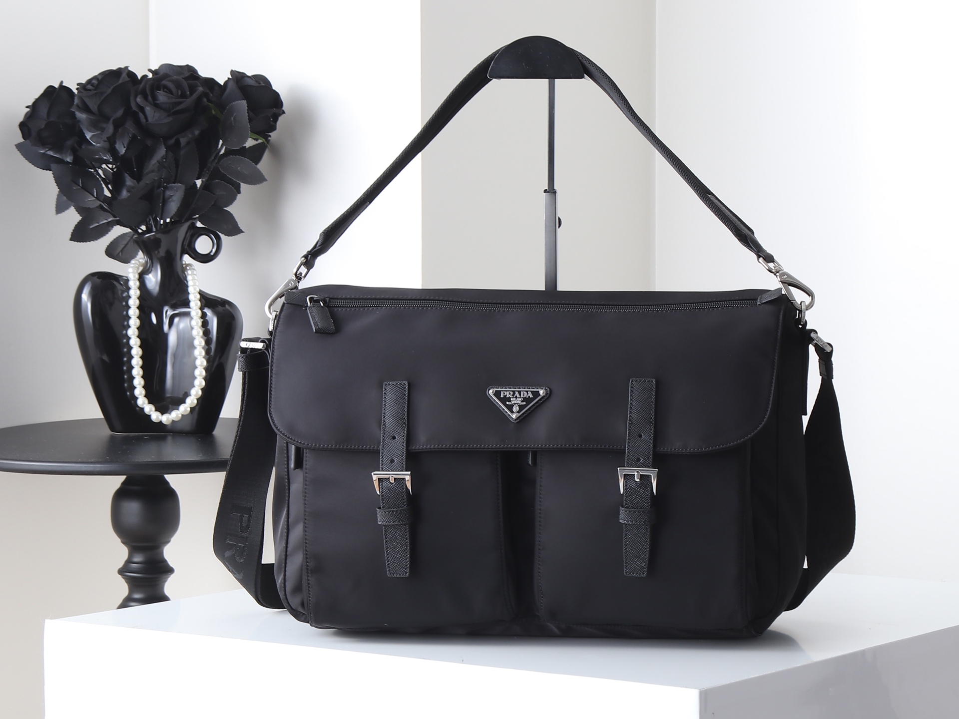 NO:940978,Model 2VD072 Color: Black This handbag combines functionality and aesthetic exploration, presenting a neat and modern design. Made of Re-Nylon (regenerated nylon) material, the practical bag combines exquisite technical details to interpret an elegant urban style. The multi-pocket design and unique piping outline the dynamic temperament of this accessory, and the iconic enameled metal triangle logo is the finishing touch. Removable padded nylon strap handle  Adjustable woven nylon strap with straps Maximum length: 130 cm - Minimum length: 70 cm - Maximum drop: 60 cm - Minimum drop: 30 cm Enameled triangular metal logo on the front Flap with zipper closure 3 outer zip pockets Internal zip pocket and patch pocket Recycled nylon logo printed lining Width: 39 cm, Height: 26 cm, Length: 18 cm, Prada [price in quantity], prada19860909型号2VD072颜色:黑色 这款手袋将功能性与美学探索融于一体,呈现利落摩登的设计.采用Re-Nylon(再生尼龙)材质,实用包型融合精致科技细节,演绎高雅都市风格.多口袋设计与别致滚边勾勒出这款配饰的动感气质,标志性的涂珐琅金属三角形徽标为整体点睛收束. 可拆卸填充尼龙带提手 可调节编织尼龙饰带肩带最大长度:130厘米-最小长度:70厘米-最大垂长:60厘米-最小垂长:30厘米正面涂珐琅三角形金属徽标 翻盖与拉链开合3个拉链外袋 内部拉链口袋和贴袋 再生尼龙徽标印花衬里 宽度:39厘米,高度:26厘米,长度:18厘米,普拉达【跑量价】,prada,Bag