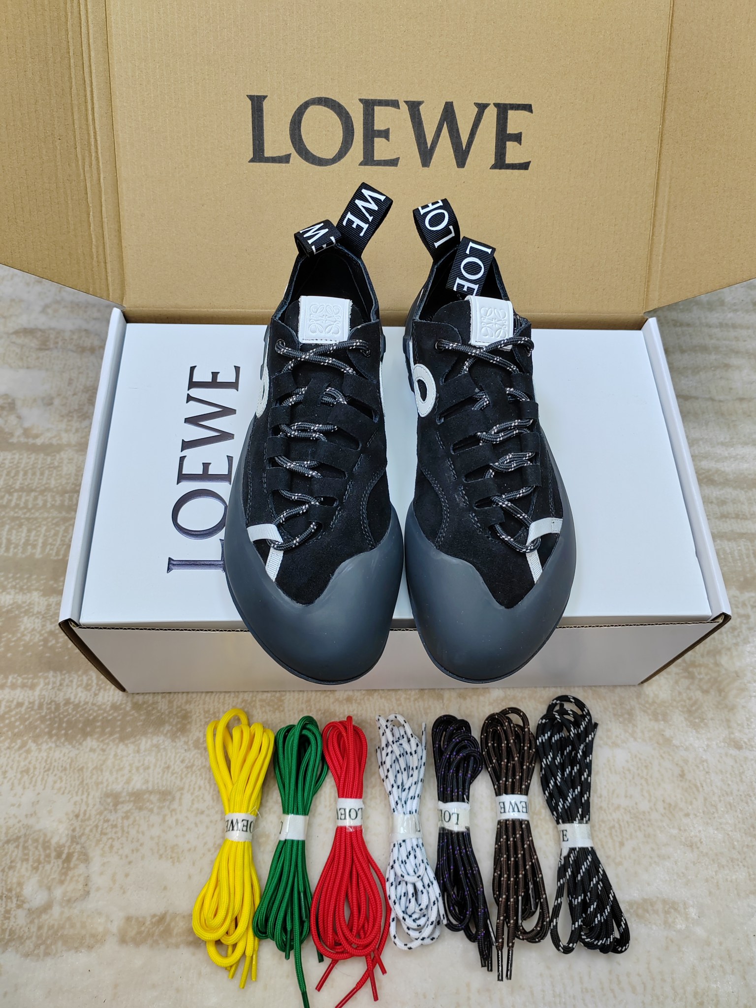 NO:779577,299 [With airplane case, same price for men and women, 85-45] LOEWE's latest spring and summer mountaineering casual shoes for couples. Many celebrity Internet celebrities have planted grass. The uppers are mostly suede/suede + nylon splicing. The toe is wrapped with thickened rubber, which is anti-kick and anti-collision, and has outdoor properties; the lining is fine lambskin, skin-friendly and comfortable. The iconic element is LOEWE's Anagram embossing or L-shaped monogram on the side of the shoe.  The logo, the heel label is printed with the word LOEWE, and the honey-colored rubber outsole extends to the toe, which is highly recognizable. The round blunt toe + wide last design gives an 'ugly' feeling, and the upper foot is small. It is suitable for pairing with jeans and casual pants. It is a popular representative shoe of 'quiet luxury style' in recent years. The original molded outsole is sized 35-40 for women.  Male 39-45 (female 40, male 45 customized),,loewe,loewe,jeans,sheepskin,chamois leather19860909299【配飞机盒,男女款同价85-45】 LOEWE罗意威春夏最新情侣款登山休闲鞋 超多明星网红种草 鞋面多为麂皮/绒面革+尼龙拼接,鞋头采用加厚橡胶包裹,防踢防撞,户外属性拉满；内里是细腻小羊皮,亲肤舒适 标志性元素鞋侧有 LOEWE 的 Anagram 压纹或 L 形 monogram 标识,后跟标签印有 LOEWE 字样,蜂蜜色橡胶大底延伸至鞋头,辨识度极高 圆钝鞋头+宽楦设计,呈现“丑萌”感,上脚显脚小,搭配牛仔裤、休闲裤都很适配,是近年流行的“静奢风”代表鞋款原版开模大底码数女35-40 男39-45（女40,男45定做）,,loewe,loewe,jeans,sheepskin,chamois leather,Men's shoes