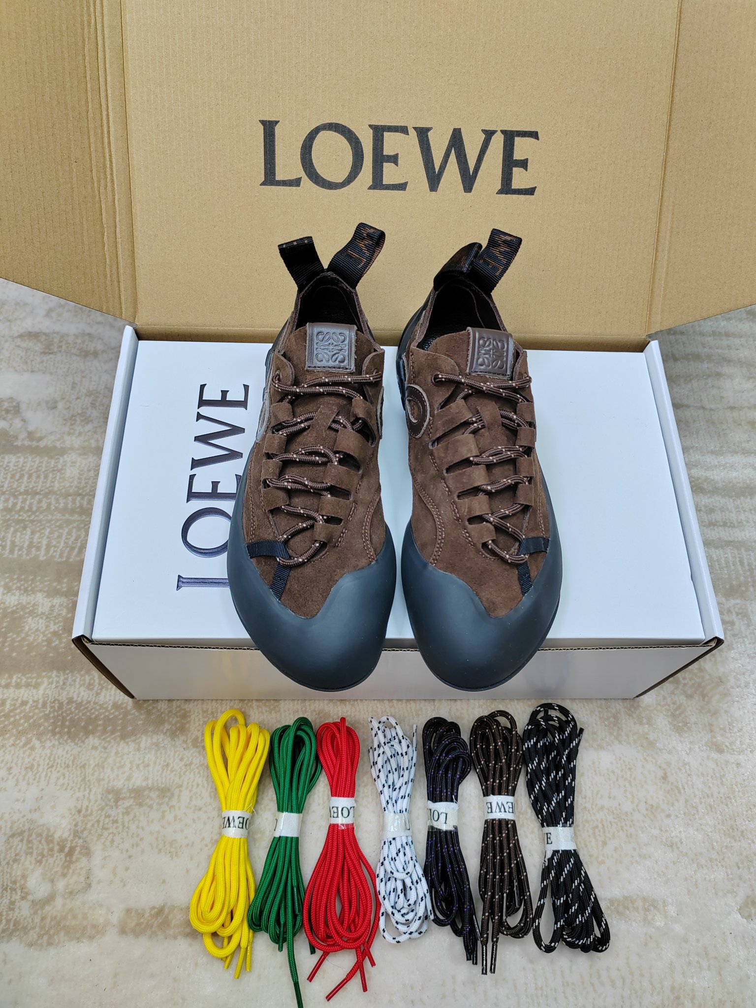 NO:779534,299 [With airplane case, same price for men and women, 85-45] LOEWE's latest spring and summer mountaineering casual shoes for couples. Many celebrity Internet celebrities have planted grass. The uppers are mostly suede/suede + nylon splicing. The toe is wrapped with thickened rubber, which is anti-kick and anti-collision, and has outdoor properties; the lining is fine lambskin, skin-friendly and comfortable. The iconic element is LOEWE's Anagram embossing or L-shaped monogram on the side of the shoe.  The logo, the heel label is printed with the word LOEWE, and the honey-colored rubber outsole extends to the toe, which is highly recognizable. The round blunt toe + wide last design gives an 'ugly' feeling, and the upper foot is small. It is suitable for pairing with jeans and casual pants. It is a popular representative shoe of 'quiet luxury style' in recent years. The original molded outsole is sized 35-40 for women.  Male 39-45 (female 40, male 45 customized),,loewe,loewe,jeans,sheepskin,chamois leather19860909299【配飞机盒,男女款同价85-45】 LOEWE罗意威春夏最新情侣款登山休闲鞋 超多明星网红种草 鞋面多为麂皮/绒面革+尼龙拼接,鞋头采用加厚橡胶包裹,防踢防撞,户外属性拉满；内里是细腻小羊皮,亲肤舒适 标志性元素鞋侧有 LOEWE 的 Anagram 压纹或 L 形 monogram 标识,后跟标签印有 LOEWE 字样,蜂蜜色橡胶大底延伸至鞋头,辨识度极高 圆钝鞋头+宽楦设计,呈现“丑萌”感,上脚显脚小,搭配牛仔裤、休闲裤都很适配,是近年流行的“静奢风”代表鞋款原版开模大底码数女35-40 男39-45（女40,男45定做）,,loewe,loewe,jeans,sheepskin,chamois leather,Men's shoes