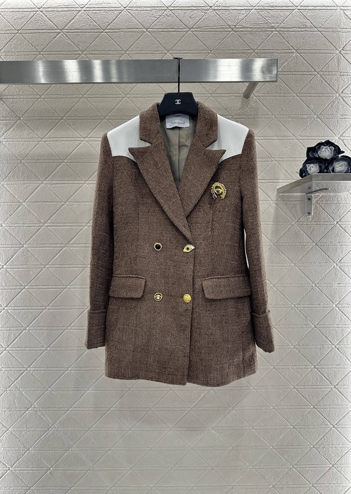 Stijlvolle tweed blazer met contrasterende details en Horus-oog broche