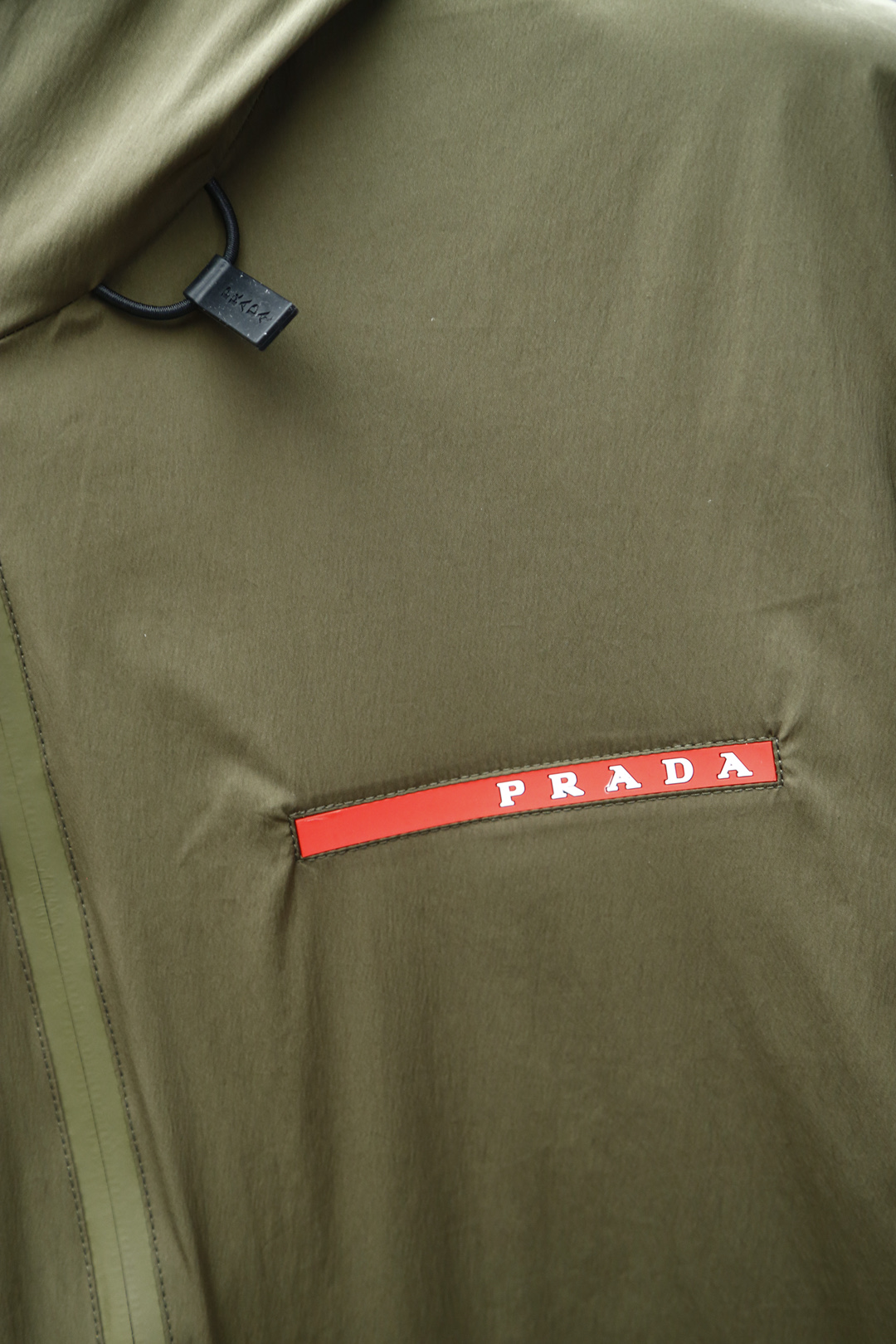 
Prada普拉达，25新品春款男士连帽开合夹克，这款休闲感十足的拉链夹克以轻质尼龙提花面料匠心打造，简