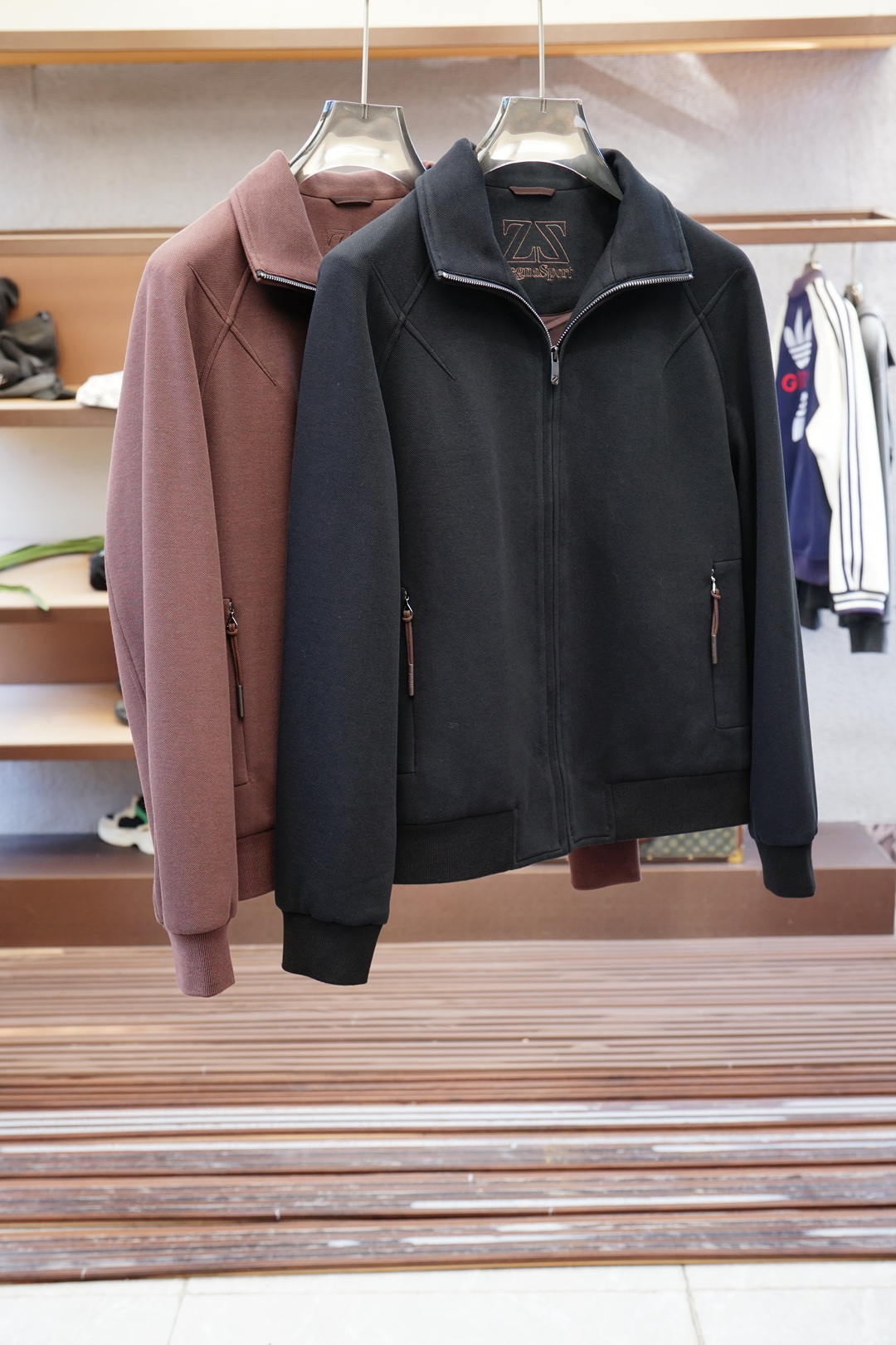 NO:531619,ZEGNA/Jenia 2025fw men's spring and summer new Moto stand-up collar design maintains a sense of fashion, but also resists wind and cold to a certain extent. The collar has a brand label inside, with the word 'ZEGNA' printed on the label, which highlights the brand identity, and is also marked with 'HIGH PERFO', which implies the high-performance fabric characteristics of this jacket. The zipper has a high-quality texture, and the zipper head has the word 'ZEGNA' on the zipper head, and the zipper zipper is made of the same color as the jacket (taking the red model as an example), which has a stronger overall feeling. The zipper is smooth and easy to pull, and can fit the neckline well when closed, enhancing the windproof effect. The button design is adopted, and the button is engraved with the 'ZEGNA' brand logo, which not only adjusts the tightness of the cuffs according to needs, but also increases the detail and exquisiteness of the jacket.  The hem has an elastic edge-closing design, which can better fit the body and keep warm, while also shaping a better dressing look to avoid loose hem affecting the overall beauty. There is a brand logo strip decoration under the neckline of the back, adding a hint of highlight and uniqueness to the overall simple design, making the back shape not monotonous. This fiber is composed of 51 polyester fiber, which is made of microfiber material. This fabric has wear resistance and easy to care for, and is suitable for daily wear. Size 48-56,,zegna, jackets & coats, jackets & coats, alexander wang19860909ZEGNA/杰尼亚 2025fw男装春夏新品Moto 立领设计,在保持时尚感的同时,还能在一定程度上抵御风寒.领口内部带有品牌标签,标签上印有“ZEGNA”字样,彰显品牌身份,同时还标注有“HIGH PERFO”,暗示了这款夹克的高性能面料特质. 拉链质感高级,拉链头上带有“ZEGNA”字样,并且拉链拉片采用与外套同色的材质（以红色款为例）,整体感更强.拉链顺滑易拉,闭合时能很好地贴合领口,增强防风效果. 采用纽扣设计,纽扣上刻有“ZEGNA”品牌标志,不仅可以根据需求调节袖口的松紧度,同时也增加了夹克的细节感和精致感 . 下摆处带有弹性收边设计,能够更好地贴合身体,保持温暖,同时也能塑造更好的穿着造型,避免下摆松散影响整体美观. 背部领口下方带有一块品牌标志条形装饰,为整体简约的设计增添了一丝亮点和独特性,使背部造型不单调. 这款纤维成分为51聚酯纤维,属于微纤维材质,这种面料具有耐磨、易打理等特点,适合日常穿着.尺码 48-56,,zegna,jackets & coats,jackets & coats,alexander wang,Men's clothing