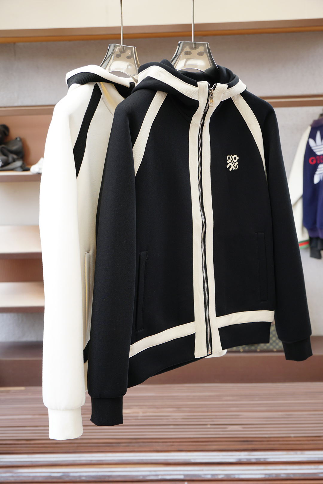 NO:539005,Loewe/Loewe-2025 new autumn and winter products, the latest series of jackets/reshapes the street high-end feel is not conventional, light and stylish. This season Y creates this popular jacket/body 1 with a new composite fabric, which uses 94 polyester fiber + 6 spandex, taking into account the light texture and outstanding elasticity; partially matched with body 2 fabric, 78 polyester fiber + 22 nylon, further improving the overall functional performance. Special surface treatment technology gives the fabric a delicate and shiny luster, tightly woven structure, lightweight locking temperature, completely breaking the heavy feeling of autumn and winter wear. Full three-dimensional tailoring·Details are ingenious  The wide three-dimensional cutting does not overly stick to the body's outline, creating a full sense of space and high-end visual lines, interpreting unique fashion language. The multi-cut piece splicing design makes the upper body look fashionable and atmospheric. The overall use of the same color double-line sewing edge-border technology, from the brim to the hem, each line is precise and exquisite, showing a luxurious connotation in a low-key manner. Whether it is street style or fashion mixing, it is easy to show a casual but exquisite dressing attitude. Color black and white Size M-3XL red, loewe, loewe, jackets & coats, hats, alexander wang19860909罗意威/Loewe-2025 秋冬季新品,最新系列外套/重塑街头高级感不拘常规,轻盈有型.本季Y以全新复合面料打造这款人气外套/主体1采用94聚酯纤维+6氨纶,兼顾轻盈质感与出众弹性；局部搭配主体2面料,78聚酯纤维+22锦纶,进一步提升整体机能表现.特殊表面处理工艺,赋予织物细腻微光泽,紧密织造结构轻量锁温,彻底打破秋冬穿着厚重感. 全立体剪裁·细节见匠心 宽幅立体剪裁不过分拘泥身体轮廓,营造饱满空间感与高级视觉线条,诠释独有的时尚语言.多处裁片拼接设计,上身效果时尚大气.整体采用同色系双线衍缝包边工艺,从帽檐至下摆,每一处走线精准考究,于低调中尽显奢华内涵. 无论是街头风格还是时装混搭,皆游刃有余,展现随性却不失精致的穿搭态度.颜色黑色白色 尺码M-3XL红,,loewe,loewe,jackets & coats,hats,alexander wang,Men's clothing