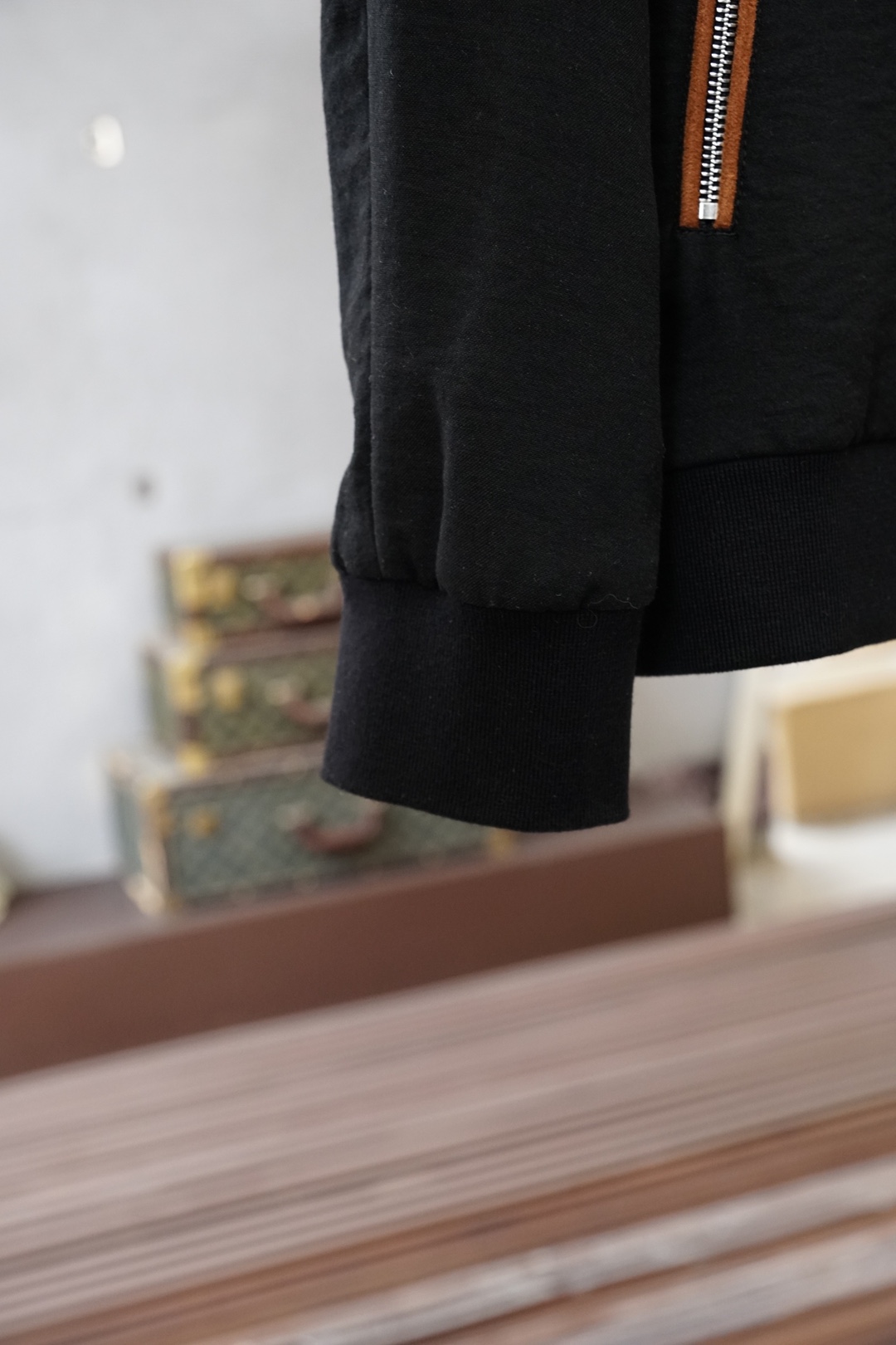 杰尼亚经典黑色立领外套，简约商务与休闲感兼具。整体黑色基底搭配棕色撞色包边，拉链、口袋线条精致高级，胸前