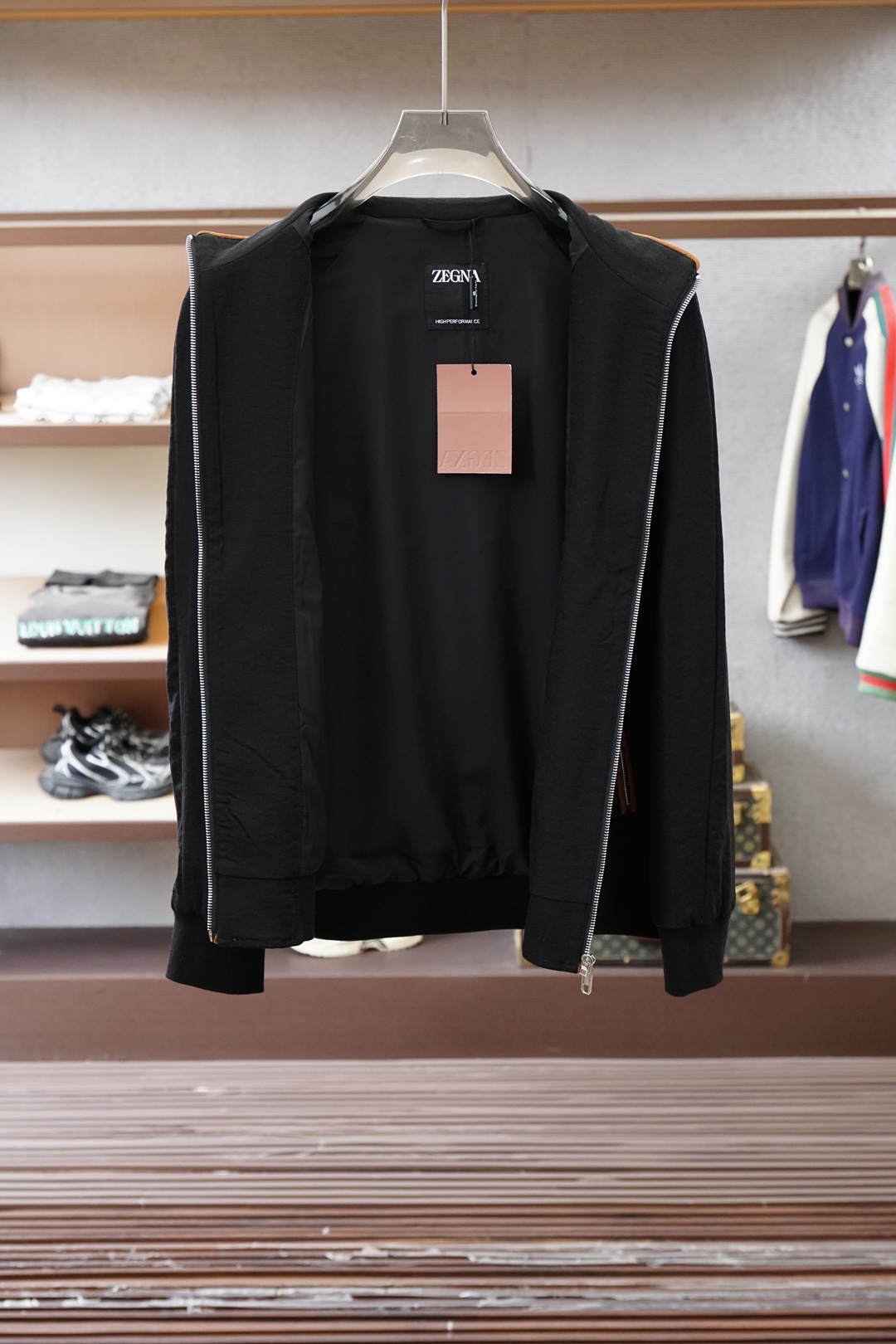 杰尼亚经典黑色立领外套，简约商务与休闲感兼具。整体黑色基底搭配棕色撞色包边，拉链、口袋线条精致高级，胸前