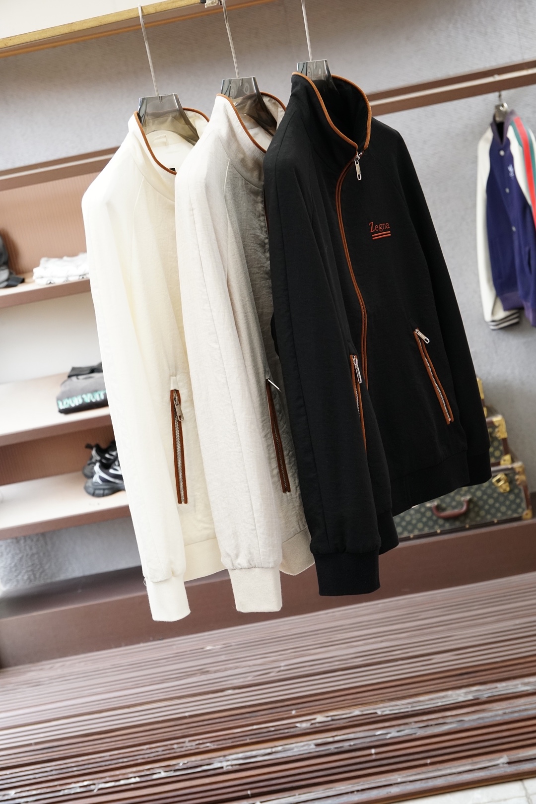 杰尼亚经典黑色立领外套，简约商务与休闲感兼具。整体黑色基底搭配棕色撞色包边，拉链、口袋线条精致高级，胸前