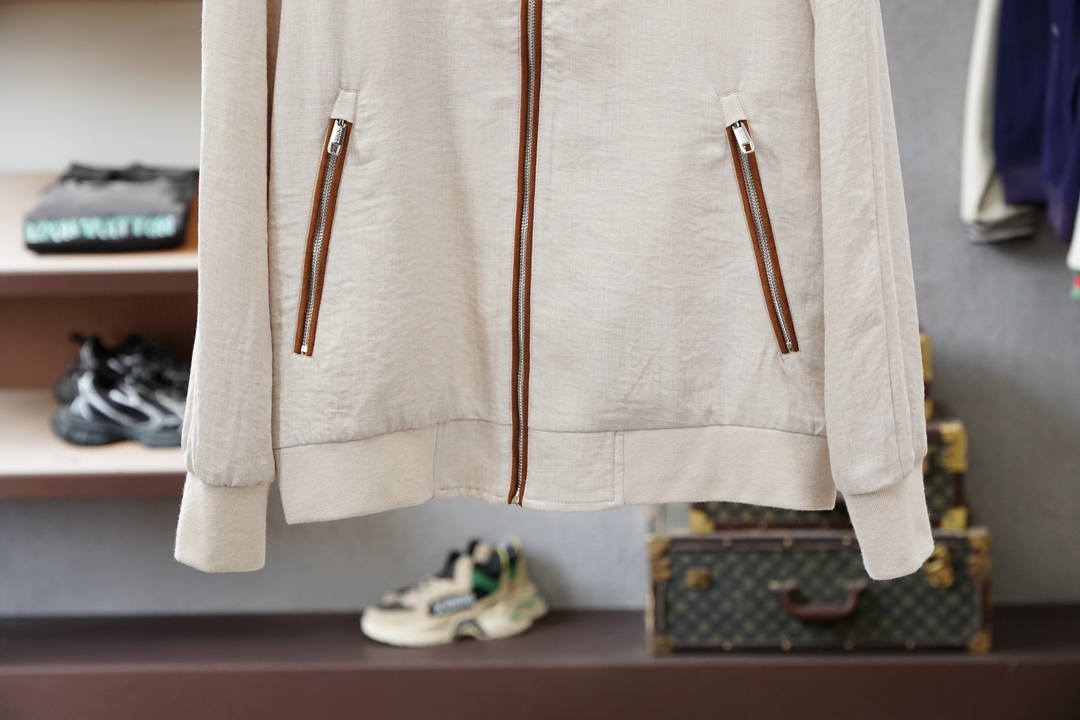 杰尼亚经典黑色立领外套，简约商务与休闲感兼具。整体黑色基底搭配棕色撞色包边，拉链、口袋线条精致高级，胸前