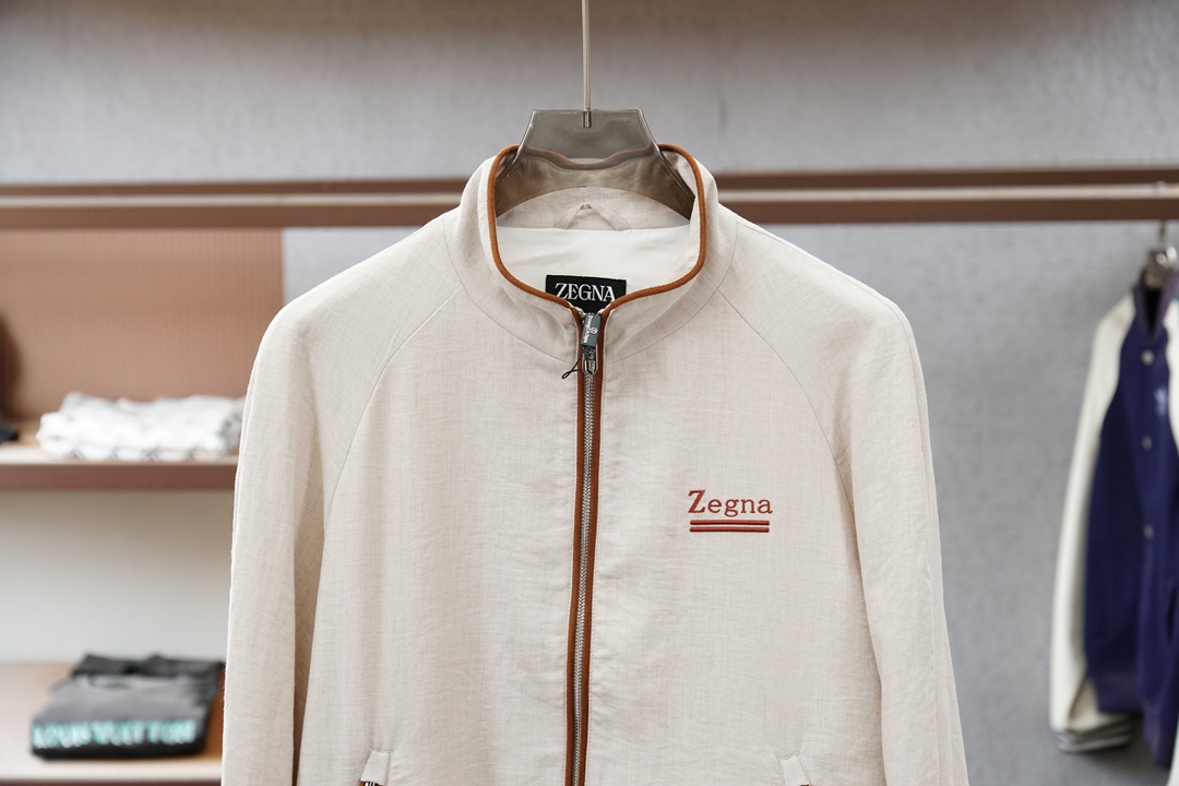 杰尼亚经典黑色立领外套，简约商务与休闲感兼具。整体黑色基底搭配棕色撞色包边，拉链、口袋线条精致高级，胸前