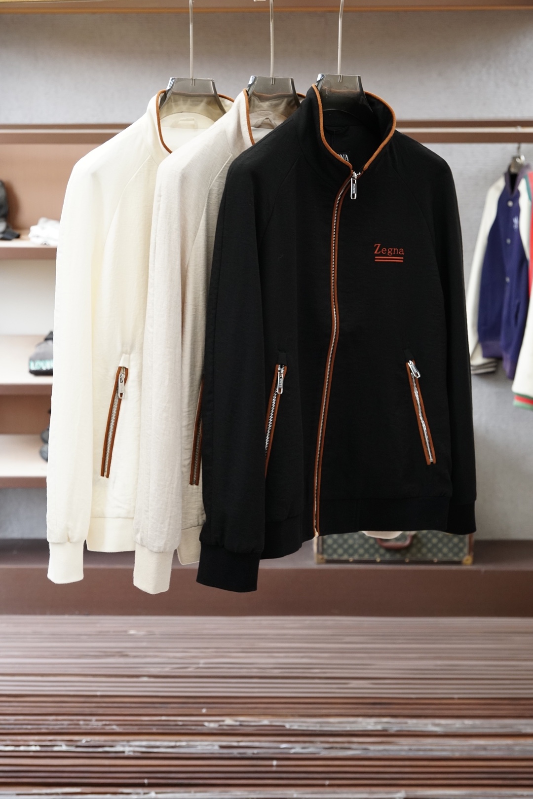 杰尼亚经典黑色立领外套，简约商务与休闲感兼具。整体黑色基底搭配棕色撞色包边，拉链、口袋线条精致高级，胸前