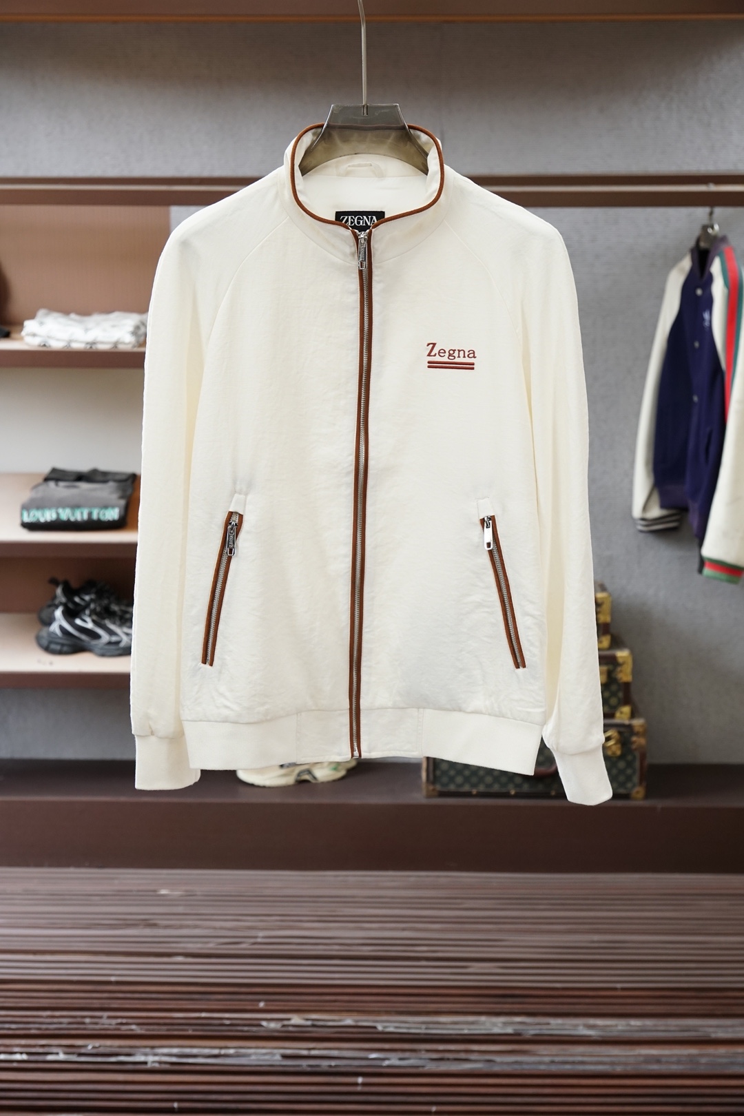 杰尼亚经典黑色立领外套，简约商务与休闲感兼具。整体黑色基底搭配棕色撞色包边，拉链、口袋线条精致高级，胸前