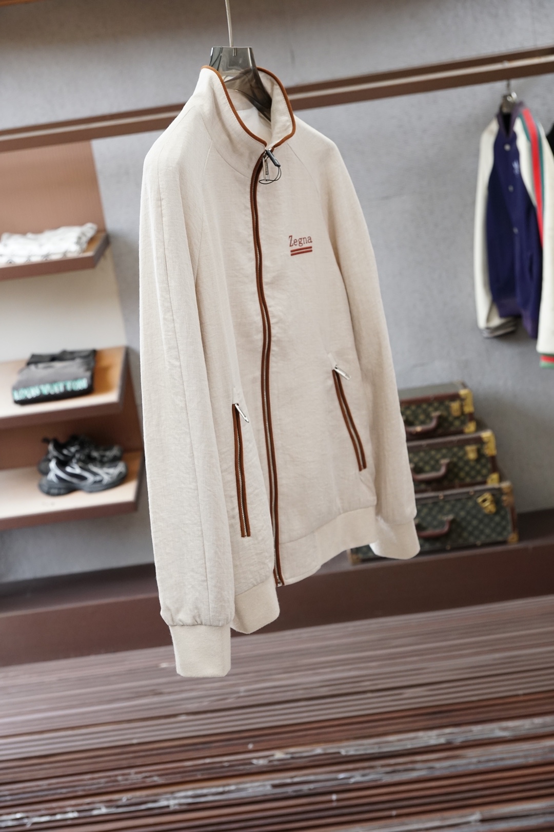 杰尼亚经典黑色立领外套，简约商务与休闲感兼具。整体黑色基底搭配棕色撞色包边，拉链、口袋线条精致高级，胸前