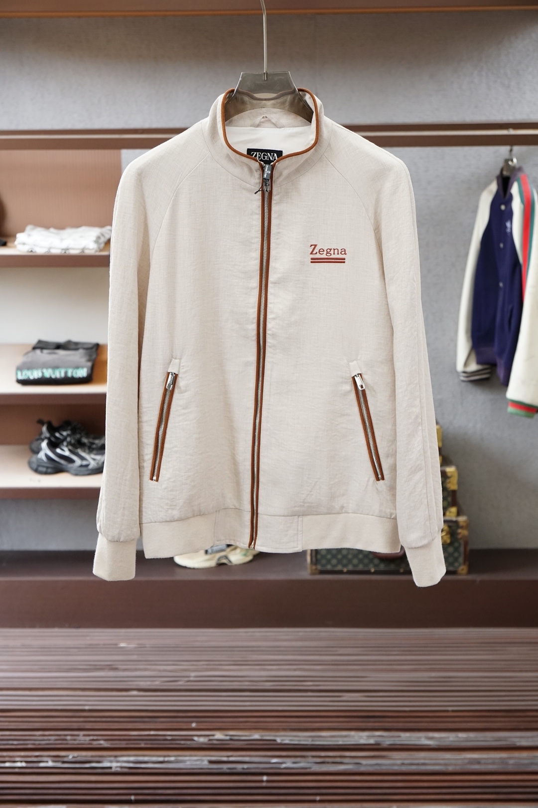 杰尼亚经典黑色立领外套，简约商务与休闲感兼具。整体黑色基底搭配棕色撞色包边，拉链、口袋线条精致高级，胸前