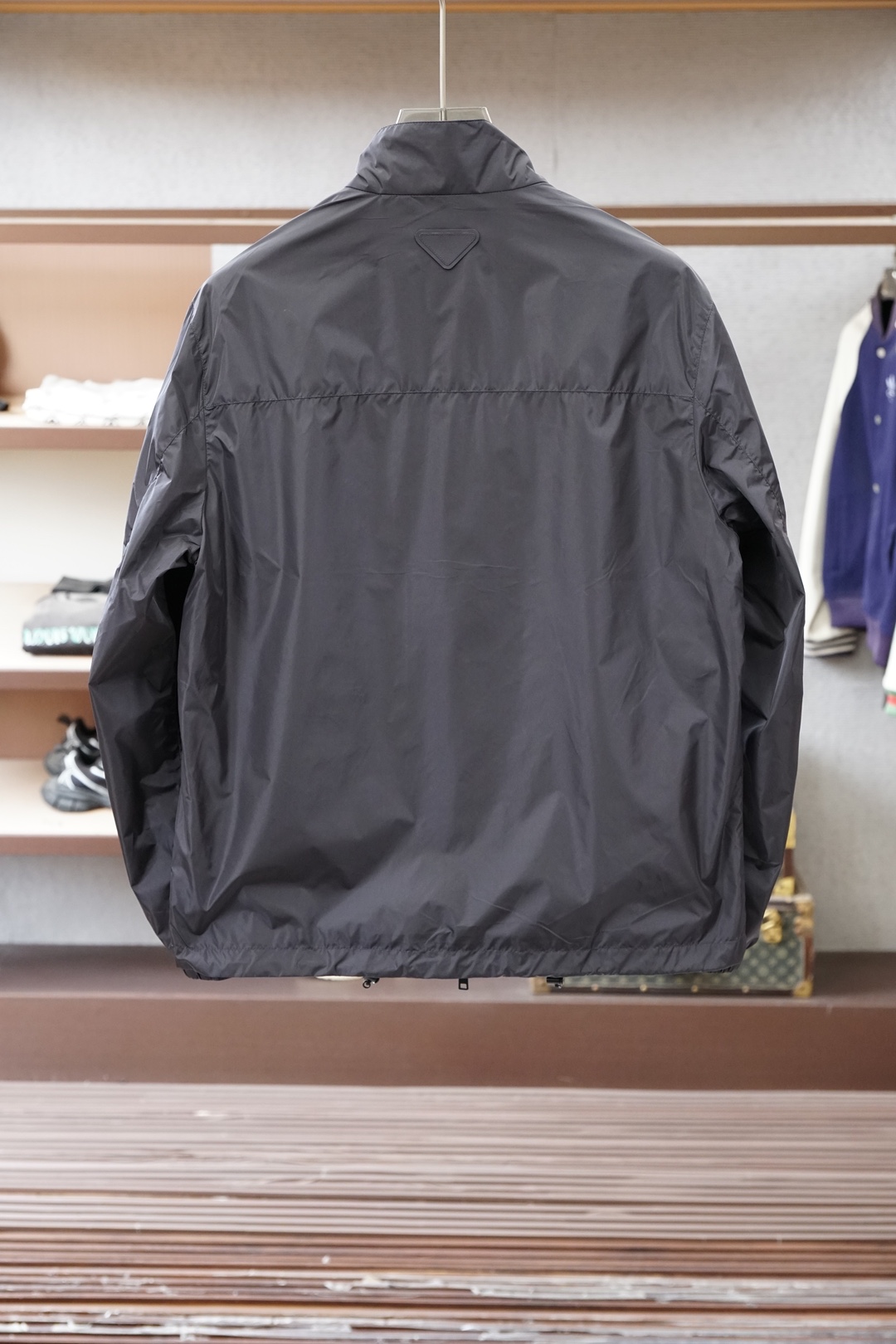 普拉达经典深灰立领轻薄外套，极简高级感拉满。哑光顺滑面料，轻便透气，日常防风又好穿。胸前标志性三角徽标，