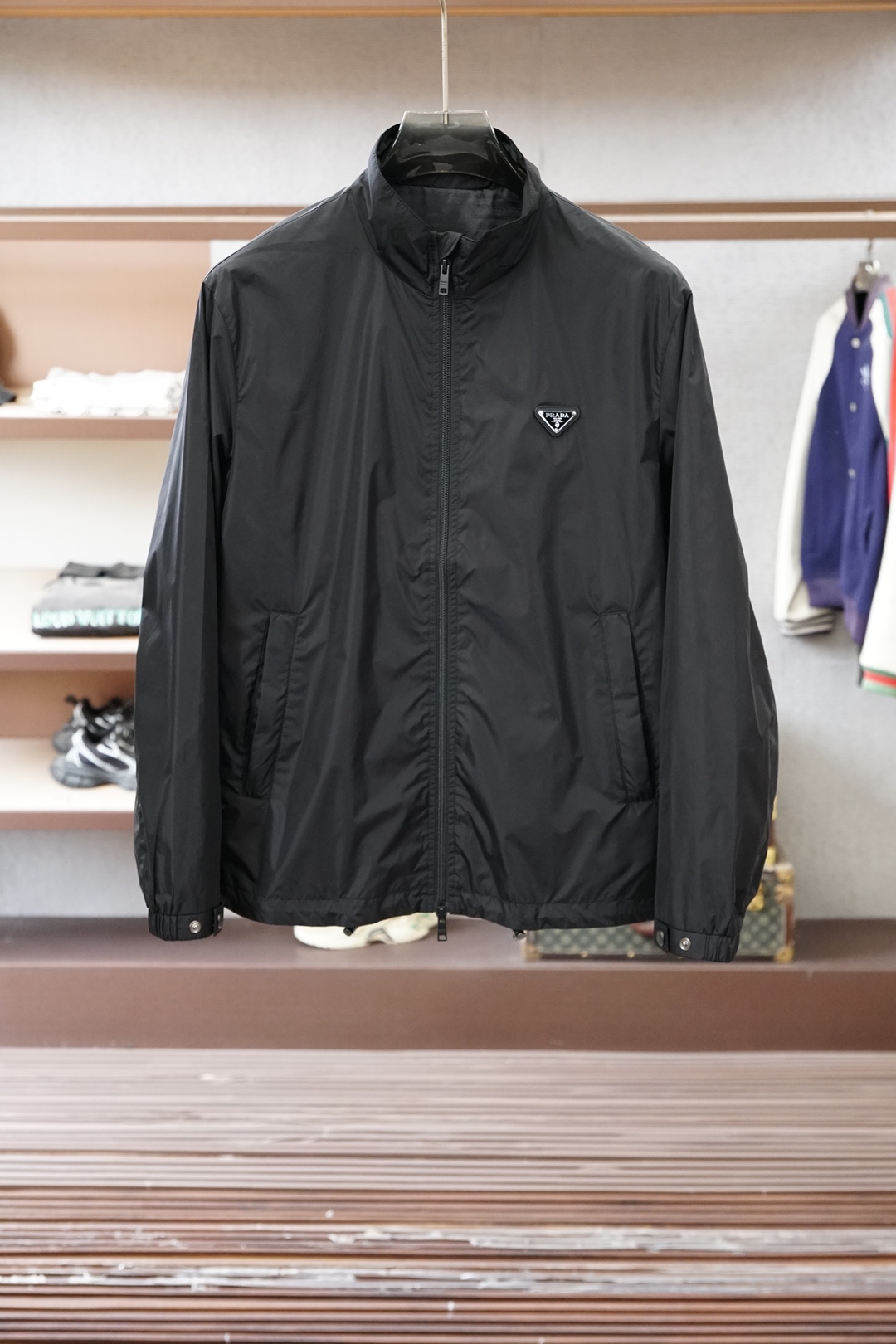 普拉达经典深灰立领轻薄外套，极简高级感拉满。哑光顺滑面料，轻便透气，日常防风又好穿。胸前标志性三角徽标，