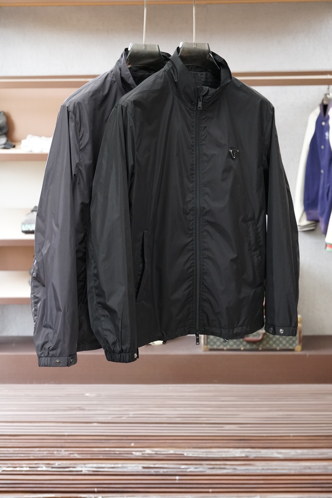 普拉达经典深灰立领轻薄外套，极简高级感拉满。哑光顺滑面料，轻便透气，日常防风又好穿。胸前标志性三角徽标，