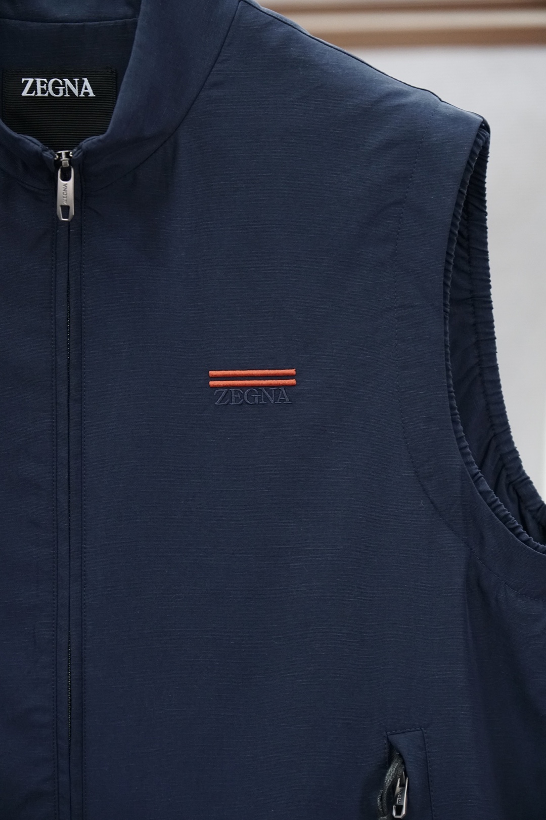 杰尼亚米白色立领马甲，简约大气，质感细腻。拉链开合设计，搭配小标刺绣，低调精致。版型宽松挺括，内搭外穿都