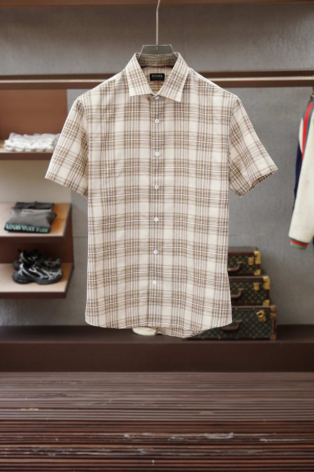 NO:857626,Ermenegildo Zegna's 26th summer men's business casual high-end plaid short-sleeved shirt series, trading company channel goods, high-end counter orders, men's wardrobe selections with extraordinary taste, 26th summer new products, treasure-level high-end items!   Ge*Asia - an Italian luxury menswear leader that started in 1910. Its century-old accumulation is synonymous with extreme craftsmanship in the field of menswear. The brand is world-renowned for its exquisitely tailored suits. It does not deliberately pursue flashy trends, but is recognized for its simple, elegant and self-contained style.  The 'noble' in the men's clothing industry. From its original worsted wool fabric workshop to now standing proudly at the top of the international luxury goods group, Jénéa has always adhered to the unswerving creed of 'innovation spirit and excellent quality'. It is an inescapable status symbol for every successful man who pursues style and pays attention to texture!   The overall design this time is unique and innovative. The whole body is intertwined with plaid lines, which is full of fashionable and youthful vitality. It fully unleashes the warm and refreshing advantages of khaki in summer. A whole row of clean and neat white natural shell buttons are crystal clear in shape, warm to the touch, and feel refreshing when opened.  The wind-like free and easy dressing experience interprets the unique natural and clean temperament. The exquisite embroidery technology on the turtle back embellishes the iconic three cross elements of Ge*Ya, which always highlights the brand's exclusive identity. The overall shape is both business capable and decent, but also casual and relaxed!   It is custom-woven from a selection of top-grade long-staple cotton in a century-old Italian workshop. The standard garment process is 100% pure cotton. The texture of the fabric is fine and soft, smooth and skin-friendly. The visually bright plaid pattern has a light and rhythmic feel unique to summer. The pure cotton material has excellent breathable and moisture-removing properties. Even if the heat is steaming, you will still feel comfortable and comfortable. The experience is wonderful!   The details are full of ingenuity, the tailoring is neat and stylish, and the shape is particularly friendly to Asian men's body shapes. The upper body does not look cramped at all. The cuffs and hem are precision hemmed and will not be easily deformed after repeated washing. It can be paired with off-white linen trousers or  Suit shorts of the same color and a pair of brown loafers or minimalist white shoes can be worn elegantly for commuting or going out on the weekends. They can be easily worn to give an effortless sense of luxury. A must-have for quality-conscious people and shirt-loving people, it is a rare find but not a must-have!  Available in sizes M-3XL, khaki is enough to unlock elegance all summer long!  ,,zegna,loafers,shorts,shirts,T-shirt,business suit,19860909杰尼亚-亚26年夏季男士商务休闲高端格纹短袖衬衫系列,贸易公司渠道货,高端专柜订单,品味非凡的男士衣橱甄选之物,26年夏季新品,宝藏级高级单品！  杰*亚——始于1910年的意大利奢级男装泰斗,百年积淀堪称男装领域极致匠心的代名词.品牌以剪裁一绝的西装享誉全球,不刻意追逐浮华潮流,却以其古朴、优雅且自成格局的风格,被公认为男装界的“贵族”.自最初的精纺羊毛面料工坊,到如今傲立国际奢侈品集团之巅,杰*亚始终坚守“创新精神、卓越品质”的不渝信条,是每一位追求格调、讲究质感的成功男士绕不开的身份符号！  此次整体的设计别具新意,通体横竖交织的格纹线条,洋溢着时尚年轻的青春活力,将卡其色在夏日的温润清爽优势尽情释出.一整排干净利落的白色天然贝壳扣,形质晶莹,触感温润,开启如沐清风般的洒脱着衣体验,演绎自然干净的独特气质.龟背处精美刺绣工艺将杰*亚标志性的三个叉元素点缀其中,无时无刻彰显品牌尊属身份.整体造型既有商务的干练得体,又不乏休闲的松弛自在！  意大利百年工坊精选顶级长绒棉定织而成,标准成衣工序,百分百纯棉打造,面料肌理细腻柔软,触感爽滑亲肤,视觉上格纹层次明快,颇具夏季特有的轻盈韵律感.纯棉材质拥有绝佳的透气排湿性能,纵使暑气蒸腾,依然自在舒爽,体验感妙不可言！  细节处处尽显匠心,剪裁利落有型,版型对亚洲男士身型尤为友好,上身丝毫不显局促.袖口与下摆均经精密锁边,反复洗涤不易变形.既可搭配米白色亚麻长裤或同色系西装短裤,脚踩一双棕色乐福鞋或极简白鞋,又可雅致通勤或周末出街,皆游刃有余,轻松穿出不费力的高级感.品控族与衬衫控必入的类型,可遇而不可求！尺码M-3XL,卡其一色足以解锁整个夏天的优雅！,,zegna,loafers,shorts,shirts,T-shirt,business suit,,Men's clothing