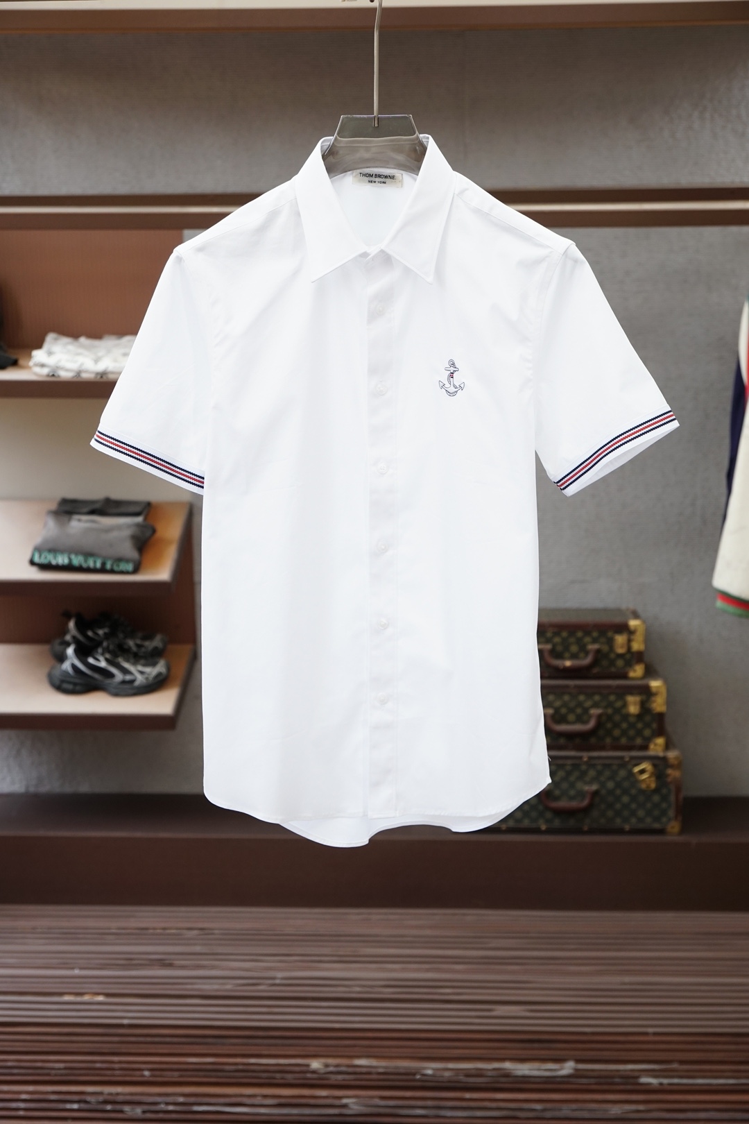 NO:857616,TB family Tom*Lang's 26-year summer men's business fashion casual high-end short-sleeved shirt series, produced by the original factory in the United States, and channeled through global boutique buyers, is a unique and representative elite men's shirt that is unforgettable in terms of vision. Today is an exclusive limited edition!   Tom Lang subverts traditional men's wear internationally with his iconic four-stripe design. He has won the CFDA Men's Wear Designer of the Year award four times, and has global annual revenue of over 10 billion yuan. His unique aesthetics has profoundly influenced the trend of global business and casual wear!   This season's design features the classic anchor icon embroidered on the chest as a logo, made with pure hand-made satin embroidery. Each stitch has been repeatedly calibrated by craftsmen. It is full-dimensional and without a trace of thread, classic and highly recognizable. A special button design at the back of the collar echoes the brand's uniform aesthetics. The cuffs are matched with classic red, white and blue wavy striped grosgrain webbing, which cleverly echoes the anchor embroidery on the chest. Both of them highlight the brand's status. They are restrained and ingenious, making them more youthful and energetic!   Exclusively for original imported high-definition blended fabrics, with a golden ratio of 97% high-quality long-staple cotton and 3% spandex. After mercerization, it is delicate and shiny. The micro-elastic effect has both wrinkle resistance and drape. The comfort and stiffness are perfectly compatible. The touch is self-evident!   The overall clear buckle design is simple and elegant, and the back collar hanging ring is unique. Every detail is an ingenious interpretation of American classics. The pure white background is paired with red, white and blue webbing and anchor embroidery, which is fashionable in business and shows off your status in a low-key manner. Outfit  In terms of style, it can be worn with slim-fitting trousers and loafers for high-end business occasions; it can also be worn with khaki casual pants or dark jeans to show the relaxed feel of urban elites. A shirt can seamlessly switch between commuting and socializing, and is the absolute ace of the summer wardrobe!  Size M~3XL,,loafers,jeans,shirts,T-shirt,gold,19860909TB家族汤姆*朗26年夏季男士商务时尚休闲高端短袖衬衫系列,美国原厂出品,全球精品买手店渠道,独具代表性的精英男士衬衫,在视觉方面让人过目难忘,今独家限定款！  汤姆*朗在国际上以标志性四道杠设计颠覆传统男装,四度斩获CFDA年度男装设计师大奖,并拥有超百亿人民币的全球年营收体量,其独特美学深刻影响了全球商务与休闲着装的潮流风向！  此季的设计中前胸搭载经典船锚图标刺绣作为标识,纯手工缎面绣工艺打造,每一针都经过匠人反复校准,立体饱满且无一丝线头,经典且极具辨识度,领部后方特制一颗纽扣设计与品牌制服美学遥相呼应,袖口搭配经典红白蓝波浪形条纹罗缎织带,与胸前船锚绣花形成巧妙呼应,两者皆彰显品牌身份地位,内敛且颇富巧思,更显年轻活力！  专供原厂进口高定混纺面料,97优质长绒棉与3氨纶黄金配比,经丝光处理后细腻有光泽,微弹力效果兼具抗皱与垂坠感,舒适性与挺括度完美兼容,触感不言而喻！  整体净版明扣设计,简约大气,后领挂环别出心裁,每一处细节皆是对美式经典的匠心诠释.纯白底色搭配红白蓝织带与船锚刺绣,商务中不失时髦,低调中尽显身价.穿搭方面,既可搭配修身西裤与乐福鞋,出入高端商务场合；亦可换上卡其休闲裤或深色牛仔裤,演绎都市精英的松弛感.一件衬衫,通勤与社交无缝切换,夏季衣橱的绝对王牌！尺码M~3XL,,loafers,jeans,shirts,T-shirt,gold,,Men's clothing