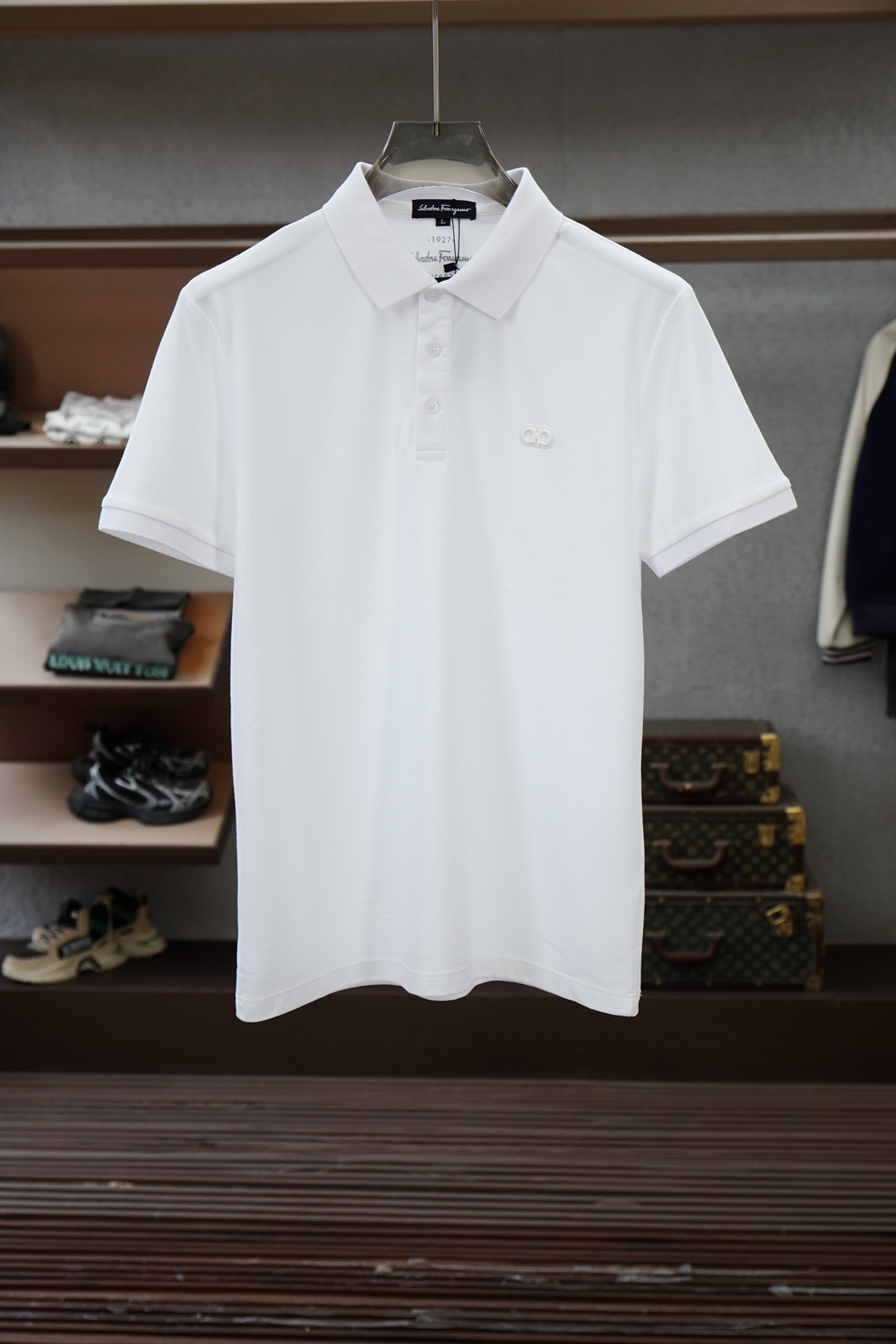 NO:836678,Ferragamo - 2026ss new product launched, classic refreshed high-end pique Polo shirt  The fabric is made of black technology and feels comfortable and luxurious when worn. It is made of double-sided piqué mesh fabric, with a three-dimensional piqué texture intertwined with warp and weft. It has a breathable mesh structure. It can keep your skin dry at all times when wearing it in summer, saying goodbye to stuffiness and stickiness. The double-sided weaving process makes the fabric more stiff, wear-resistant and long-lasting.  It is not easy to deform when worn, and it is neat and stylish when worn casually. It is anti-wrinkle and easy to take care of, making it the best choice for business trips. The classic Polo collar is matched with contrasting striped piping, and the neat lines outline the neck outline, giving a full sense of business formality; the exquisite embroidered logo on the left chest is low-key.  The brand style is unobtrusive yet self-recognizable; whether worn alone for casual everyday use or worn under a suit for a business elite look, it can easily hold up in various scenarios. From fabric selection to cutting and sewing, every process follows the production standards of big brands and is three-dimensional tailoring.  It fits the body shape without being tight, taking into account both comfort and aesthetics. The fusion of double-sided pique texture and classic design makes this Polo shirt not only a piece of clothing, but also a business card of your taste. Sizes M-3XL, ferragamo, business  suit,19860909菲拉格慕- 2026ss新品上线 经典焕新高端珠地Polo衫 面料黑科技,穿出来的舒适奢感,采用双面珠地网眼面料打造,经纬交织的立体珠地肌理,自带透气网孔结构,夏日穿着时刻保持肌肤干爽,告别闷热黏腻；双面织造工艺让面料更挺括耐磨,久穿不易变形,随手一搭都是利落型格,抗皱易打理的特性,更是商旅出行的不二之选.经典Polo领搭配撞色条纹滚边,利落线条勾勒颈部轮廓,商务正式感拉满；左胸精致刺绣标识,低调彰显品牌格调,不张扬却自带辨识度；无论是单穿打造休闲日常,还是内搭西装诠释商务精英范,都能轻松hold住各种场景.从面料甄选到剪裁缝制,每一道工序都遵循大牌制作标准,立体剪裁贴合身形不紧绷,兼顾舒适与版型美感.双面珠地的质感与经典设计的融合,让这件Polo衫不止是一件服饰,更是你的品位名片.尺码M-3XL,,ferragamo,business suit,,Men's clothing