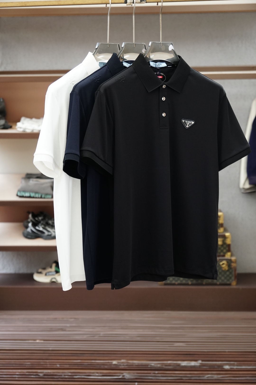 NO:843431,Prada Prada-2026ss new product launched, classic refreshed high-end pique Polo shirt  The fabric is made of black technology, giving you a comfortable and luxurious feeling. It is made of double-sided pique mesh fabric. The three-dimensional pique texture is intertwined with warp and weft. It has a breathable mesh structure. It keeps the skin dry at all times when wearing it in summer, saying goodbye to stuffiness and stickiness. The double-sided weaving process makes the fabric more stiff and wear-resistant, and can be worn for a long time.  It is not easily deformed and can be worn with any outfit. It is neat and stylish. It is anti-wrinkle and easy to care for, making it the best choice for business trips. The classic Polo collar is matched with contrasting striped piping, and the neat lines outline the neck, giving it a sense of business formality. The exquisite embroidery logo on the left chest is a low-key statement.  The brand style is unobtrusive yet self-recognizable; whether worn alone for casual everyday use or worn under a suit for a business elite look, it can easily hold up in various scenarios. From fabric selection to cutting and sewing, every process follows the production standards of big brands, and three-dimensional tailoring fits perfectly.  The body shape is not tight, taking into account comfort and shape aesthetics. The fusion of double-sided pique texture and classic design makes this Polo shirt not only a piece of clothing, but also a business card of your taste. Sizes M-3XL, prada, prada, business  suit,19860909Prada普拉达-2026ss新品上线 经典焕新高端珠地Polo衫 面料黑科技,穿出来的舒适奢感,采用双面珠地网眼面料打造,经纬交织的立体珠地肌理,自带透气网孔结构,夏日穿着时刻保持肌肤干爽,告别闷热黏腻；双面织造工艺让面料更挺括耐磨,久穿不易变形,随手一搭都是利落型格,抗皱易打理的特性,更是商旅出行的不二之选.经典Polo领搭配撞色条纹滚边,利落线条勾勒颈部轮廓,商务正式感拉满；左胸精致刺绣标识,低调彰显品牌格调,不张扬却自带辨识度；无论是单穿打造休闲日常,还是内搭西装诠释商务精英范,都能轻松hold住各种场景.从面料甄选到剪裁缝制,每一道工序都遵循大牌制作标准,立体剪裁贴合身形不紧绷,兼顾舒适与版型美感.双面珠地的质感与经典设计的融合,让这件Polo衫不止是一件服饰,更是你的品位名片.尺码M-3XL,,prada,prada,business suit,,Men's clothing
