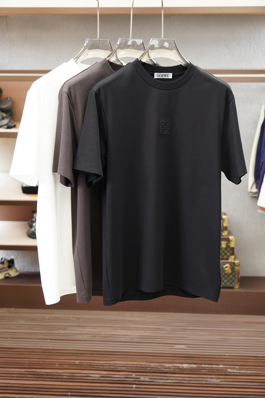 NO:950950,Loewe/|| 2026 S/S New new product 1. Color white gray 2. Size: M-5XL 3. Style: slightly wide short-sleeved T 4. Ingredients: Lenzing Modal fabric, 225 grams in weight, the surface texture of the fabric is fine and smooth, it feels skin-friendly, smooth and crisp and stylish  5. Craftsmanship: The front panel is made of contrasting colors and exquisite embroidery, and the overall design is simple. The exquisite embroidery is paired with comfortable fabrics, which is simple and high-end, loewe, T-shirt,19860909罗意威/|| 2026 S/S New 新品 1.颜色白色 灰色 2.尺码:M-5XL 3.版型:微阔短袖T 4.成份:兰精莫代尔面料,225克重,面料表面纹理细腻平整,触感亲肤顺滑且挺括有型 5.工艺:前幅采用撞色精致绣花,整体简约,精致绣花搭配舒适面料,简约又高级,,loewe,T-shirt,,Men's clothing