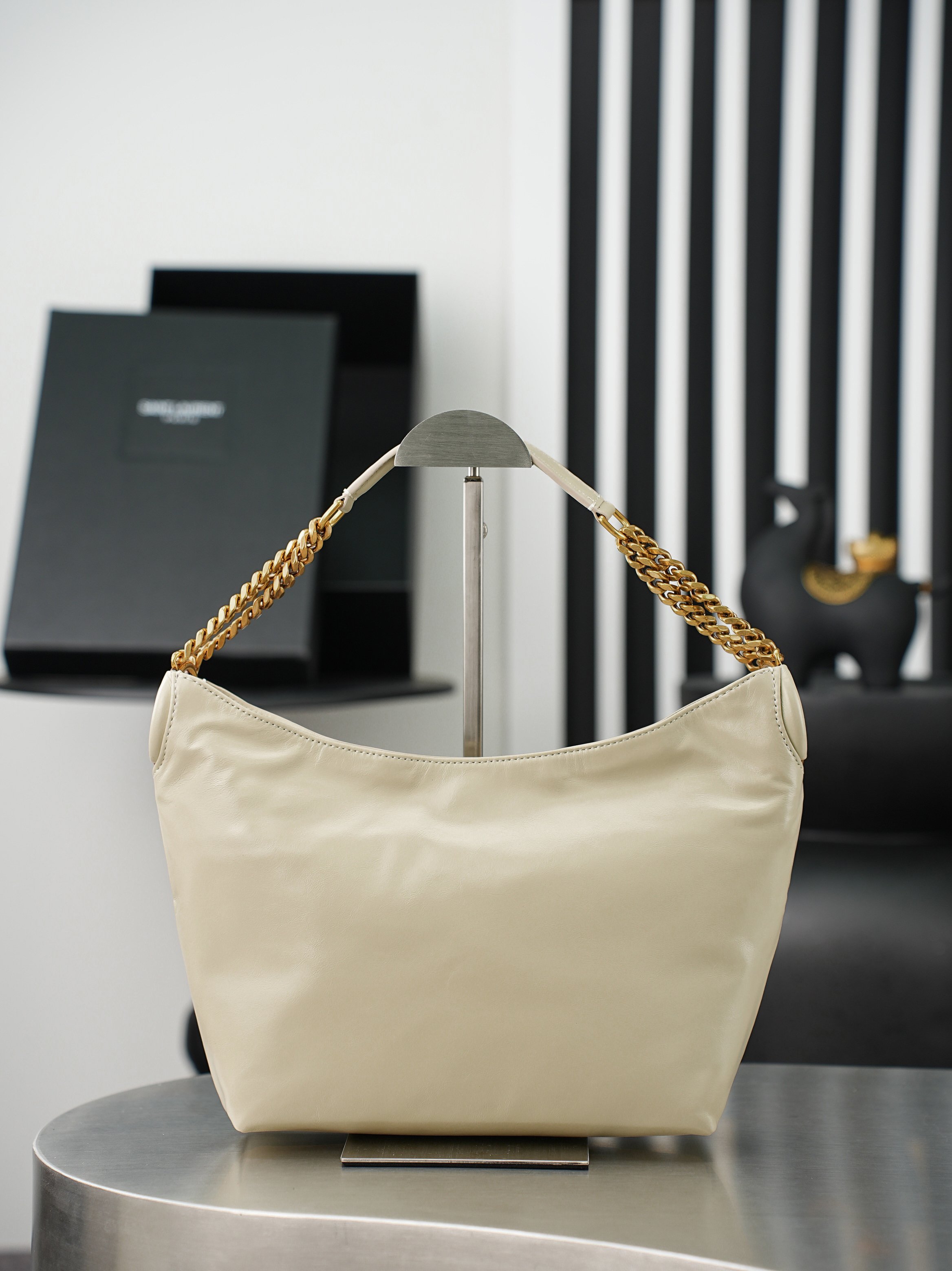 NO:855029,Batch Oil Wax White Leather/Gold YSL's latest oil wax leather chain Hobo bag, full of luster, soft and durable, full of retro feel. The metal chain shoulder strap design is exquisite and textured. The Hobo bag has a large capacity and can easily hold notebooks, water bottles and other items for daily commuting. The black color is versatile and the chain adds a sense of fashion. It can be easily held whether in casual or formal wear. It is the first choice for a practical and design bag!  Model 871222 size 23×19×9cm, saint laurent, saint laurent, saint laurent19860909批 油腊白皮/金Ysl 最新款 油蜡皮链条Hobo包,光泽感满满,手感柔软又耐用,复古感十足.金属链条肩带设计,精致又有质感,Hobo包型容量大,通勤日常都能轻松装下笔记本、水杯等物品.黑色百搭,链条增添时尚感,无论休闲还是正式穿搭都能轻松hold住,是实用与设计感兼具的包包首选！ 型号871222 尺寸23×19×9cm,圣罗兰,saint laurent,saint laurent,Bag