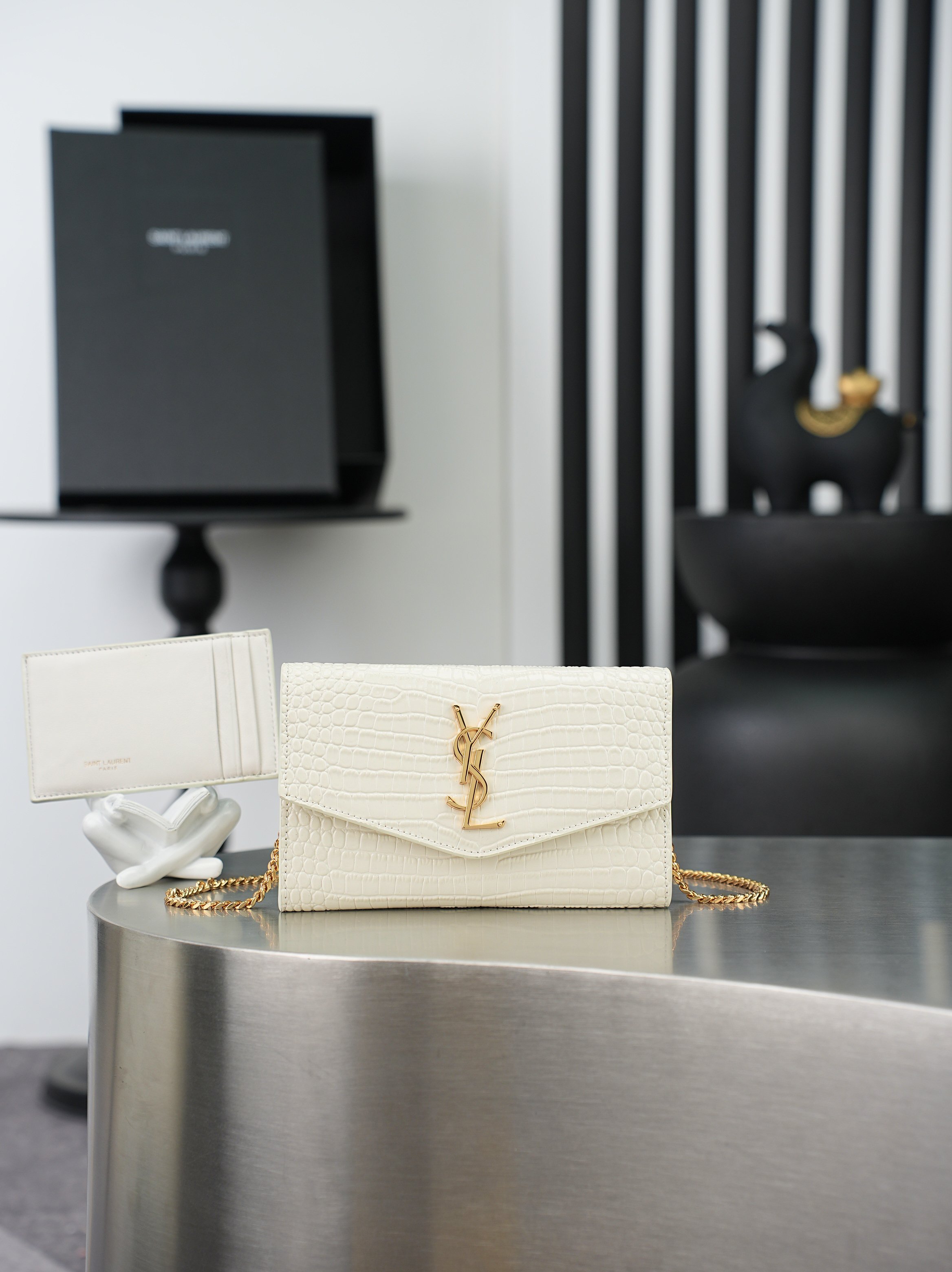 NO:895139,White crocodile pattern gold buckle · Uptown_mini envelope bag The most classic iconic metal logo, paired with a detachable chain shoulder strap, can be used directly as a handbag!  This model also comes with a small card holder, which can hold 4/5 cards no problem!  Italian imported cowhide, shoulder strap 48cm!  Although it is small enough to hold 3 Plus phones, the practicality rate is 100%!  Model 607788 size 19x12x4cm, saint laurent, saint laurent, cowhide19860909白色鳄鱼纹金扣· Uptown_迷你信封包 最经典的标志性金属Logo,搭配可拆卸链条肩背带,直接当手包！此款还配有一个小卡包,可以放4/5张卡片没问题！意大利进口牛皮,肩带48cm！虽然小确能装3部Plus手机,实用率百分百！ 型号607788 尺寸19x12x4cm,圣罗兰,saint laurent,cowhide,Bag