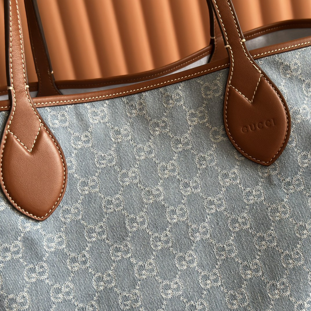 p660💋💋💋【配置专柜礼品袋】Gucci Totissima系列糅合“tote”一词与意大利语中表示最高级的词语“issima”，彰显这款手袋的实用功能和隽永底色。这款中号托特包内附可拆卸手拿包。
蓝色GG牛仔面料
棕色皮革滚边，饰对比色缝线
蓝色棉麻衬里
可拆卸手拿包：21.5厘米（宽）x 12.5厘米（高）
顶部提手（21厘米高）
型号：820481。
尺寸：30.5厘米（宽）x 28厘米（高）x 27厘米（深）
颜色：灰色牛仔面料/原厂皮。
重量：约0.6千克
意大利创作
