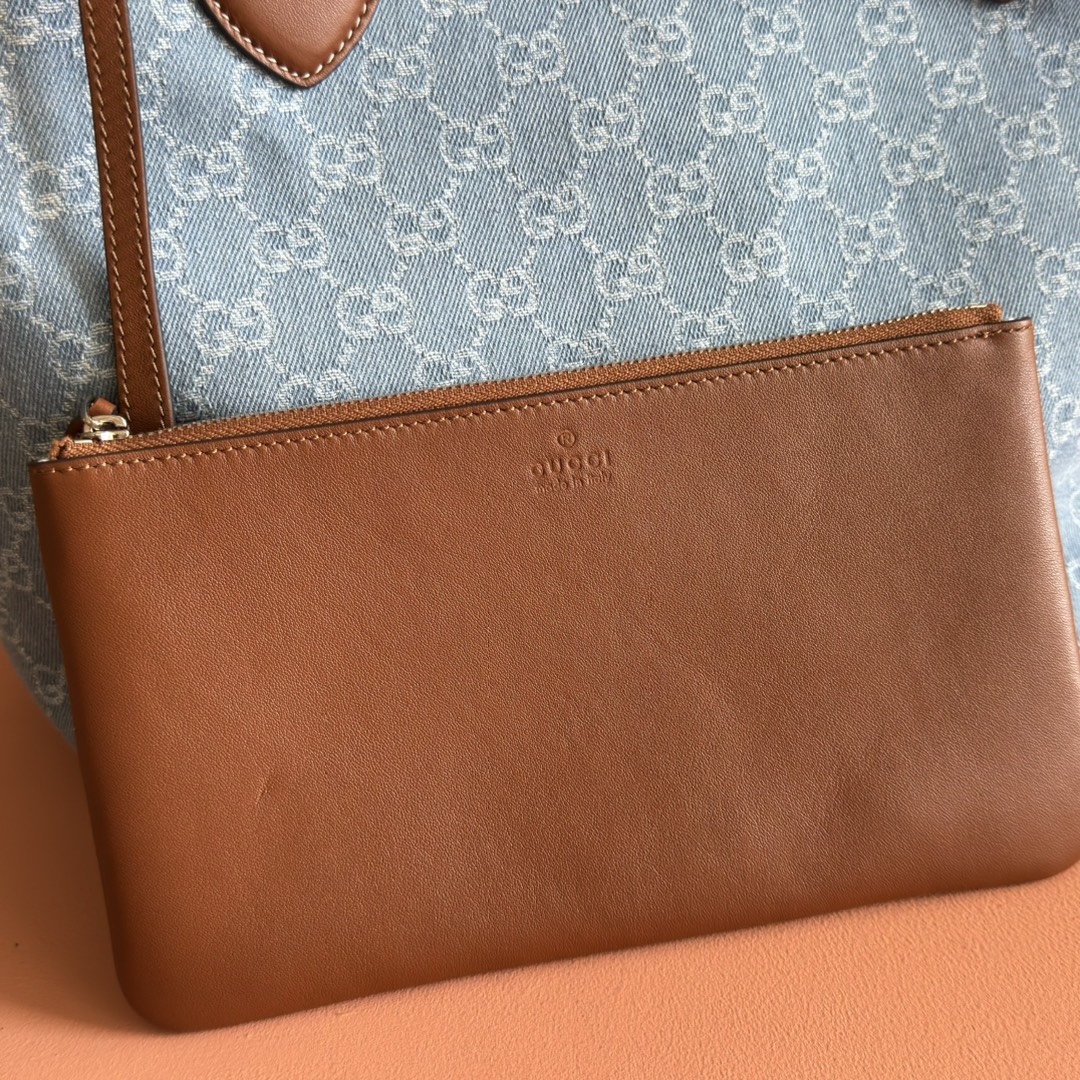 p660💋💋💋【配置专柜礼品袋】Gucci Totissima系列糅合“tote”一词与意大利语中表示最高级的词语“issima”，彰显这款手袋的实用功能和隽永底色。这款中号托特包内附可拆卸手拿包。
蓝色GG牛仔面料
棕色皮革滚边，饰对比色缝线
蓝色棉麻衬里
可拆卸手拿包：21.5厘米（宽）x 12.5厘米（高）
顶部提手（21厘米高）
型号：820481。
尺寸：30.5厘米（宽）x 28厘米（高）x 27厘米（深）
颜色：灰色牛仔面料/原厂皮。
重量：约0.6千克
意大利创作