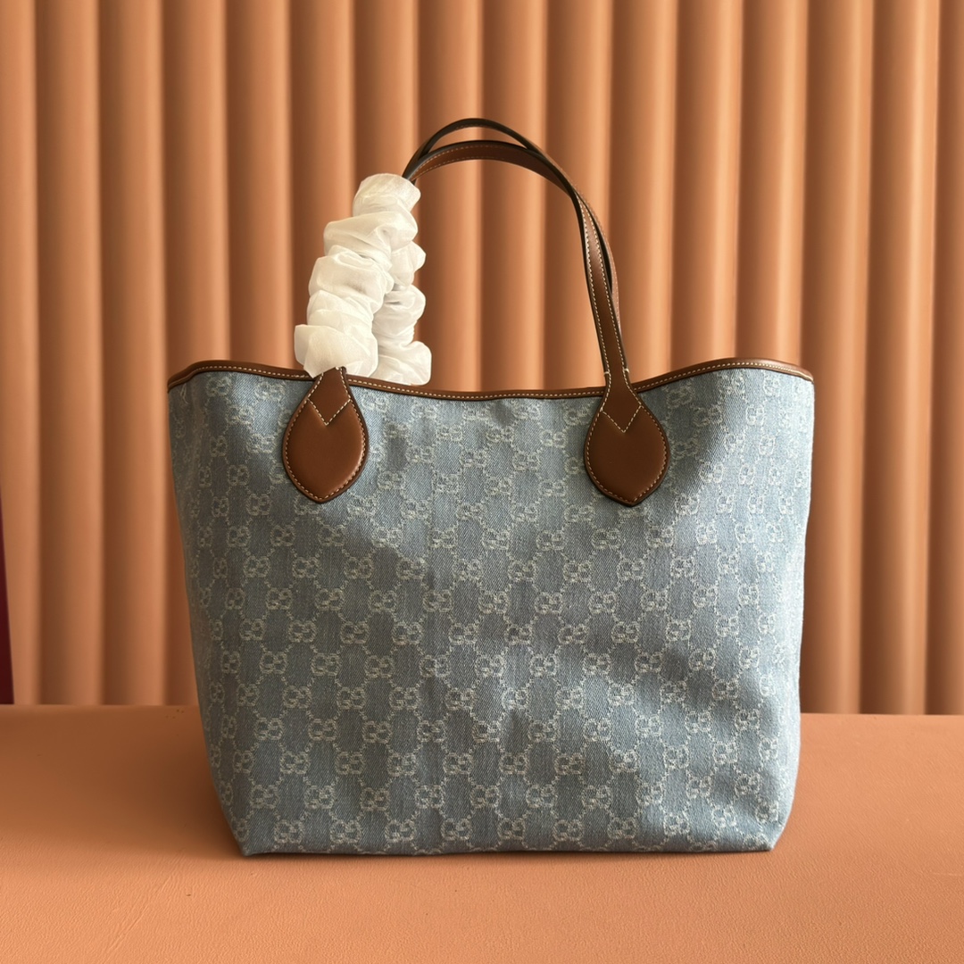 p660💋💋💋【配置专柜礼品袋】Gucci Totissima系列糅合“tote”一词与意大利语中表示最高级的词语“issima”，彰显这款手袋的实用功能和隽永底色。这款中号托特包内附可拆卸手拿包。
蓝色GG牛仔面料
棕色皮革滚边，饰对比色缝线
蓝色棉麻衬里
可拆卸手拿包：21.5厘米（宽）x 12.5厘米（高）
顶部提手（21厘米高）
型号：820481。
尺寸：30.5厘米（宽）x 28厘米（高）x 27厘米（深）
颜色：灰色牛仔面料/原厂皮。
重量：约0.6千克
意大利创作